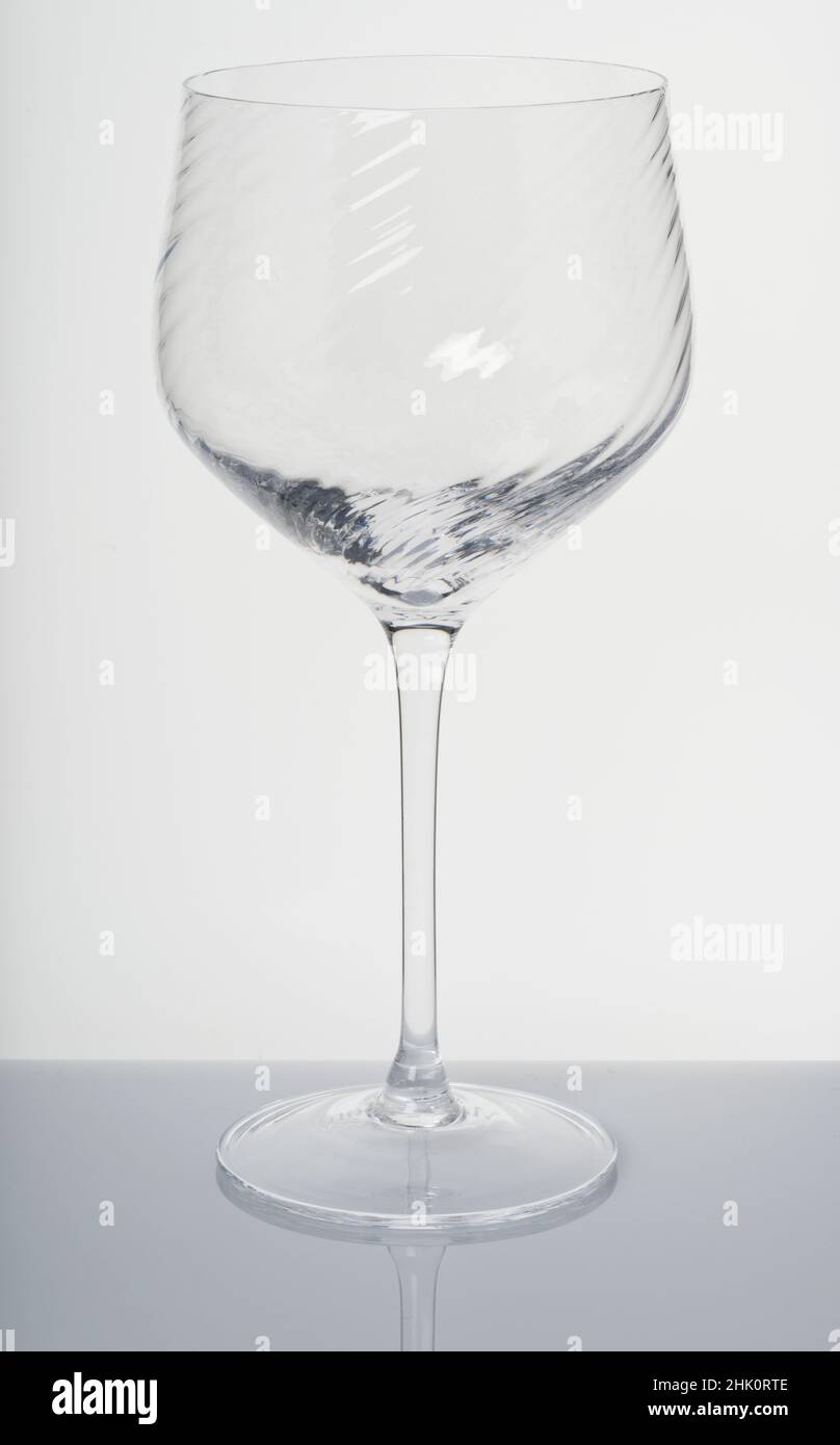 A wine glass. Glassware. Drinking vessels or drinkware. Domestic glasses for drinking liquids from. Stock Photo