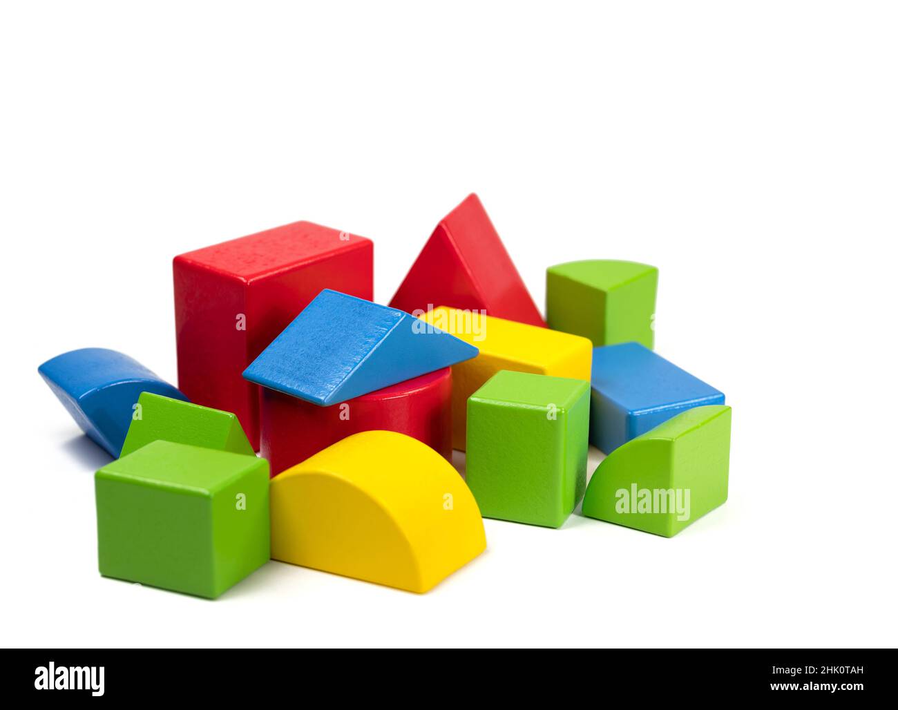 Wooden building blocks of different shapes and colors against a white background Stock Photo