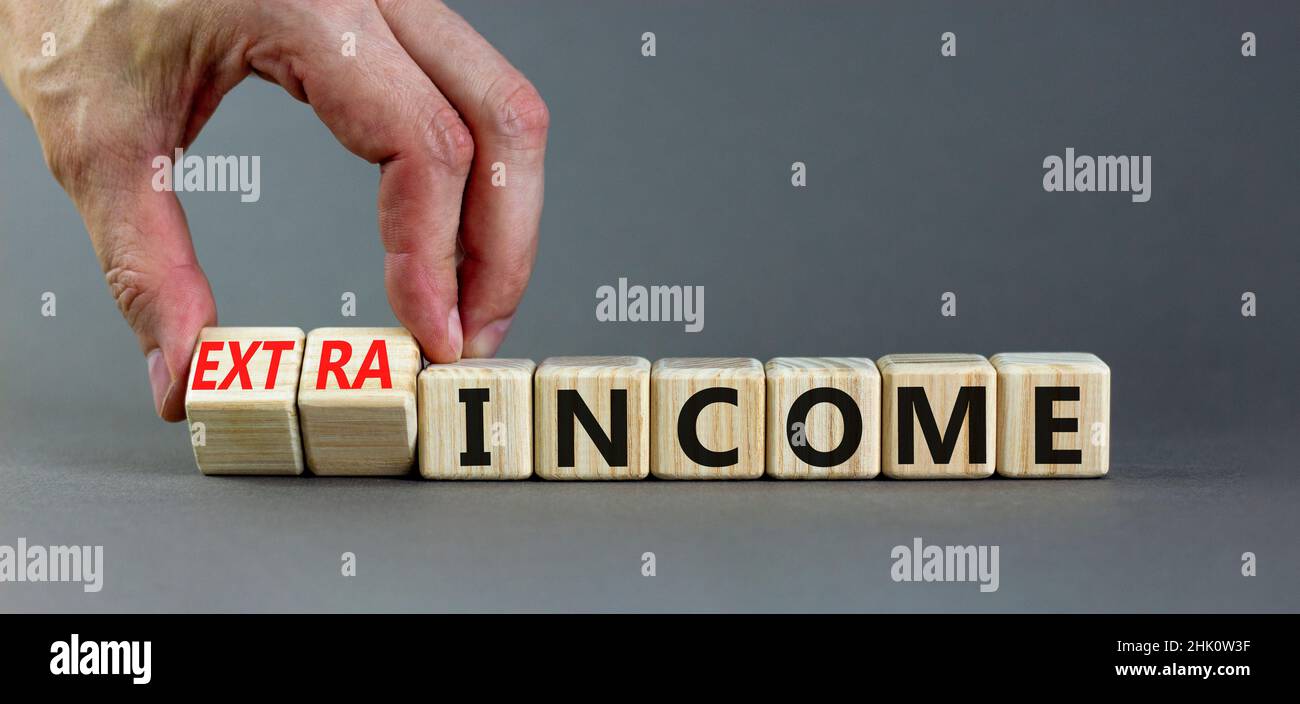 Extra Incom's Extra income symbol. Businessman turns wooden cubes and changes concept ...