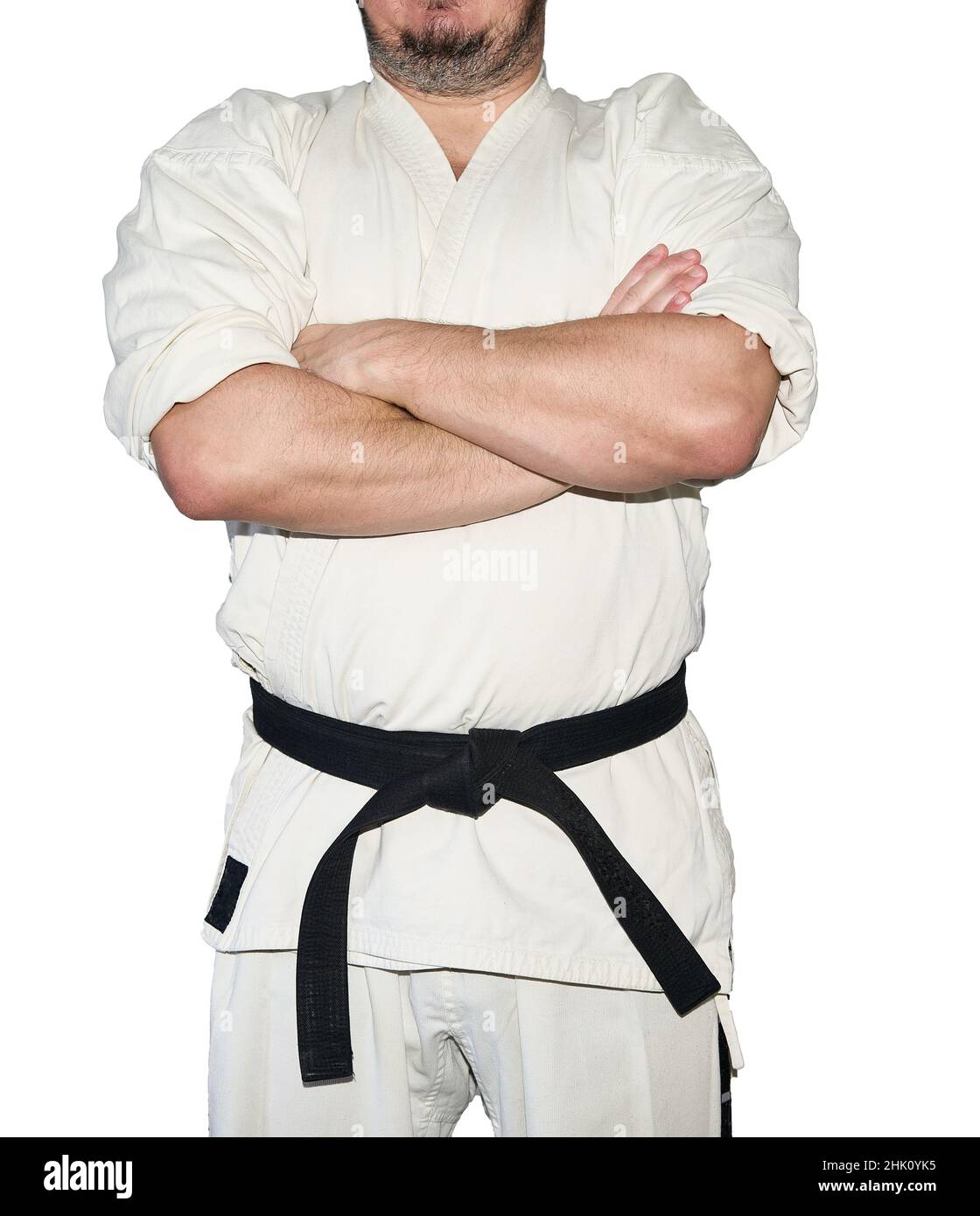 Man in karate martial arts uniform fold one's arms isolated on the