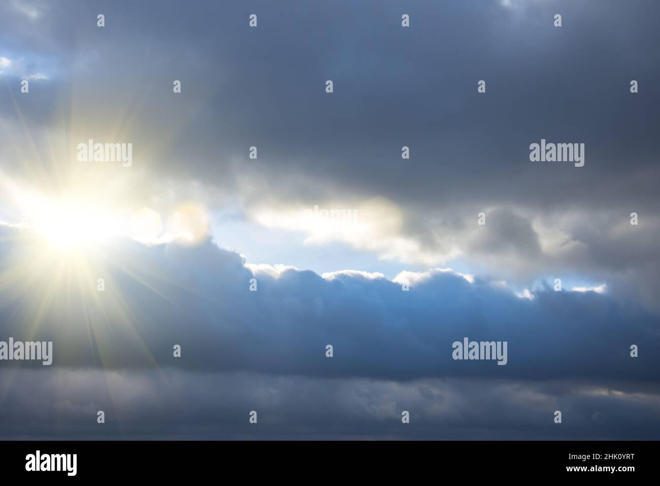 Rays of light shining through dark clouds, dramatic sky with cloud Stock Photo