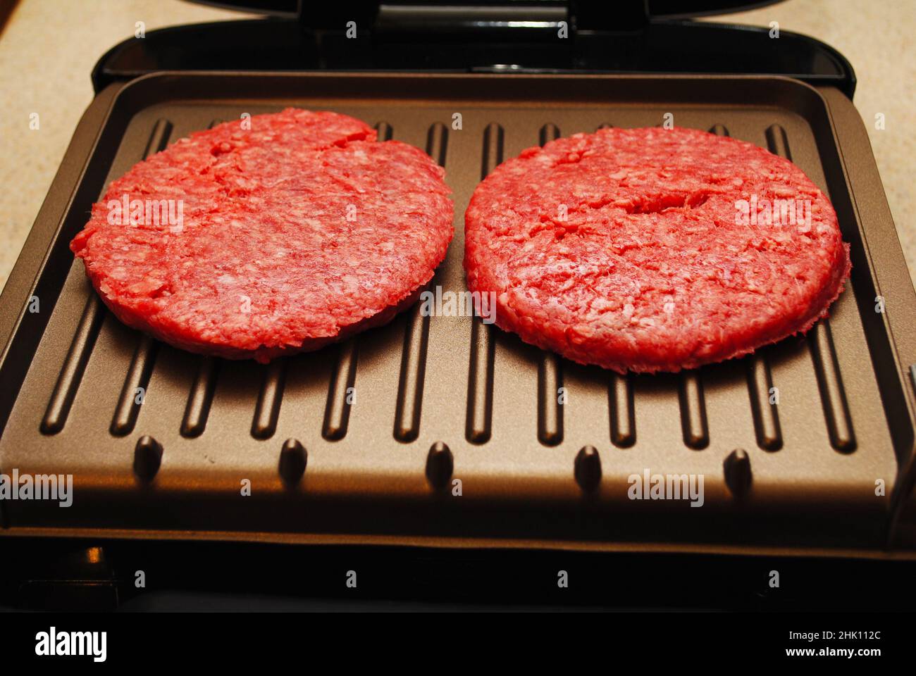 Two Raw Hamburgers on an Indoor Grill Stock Photo Alamy