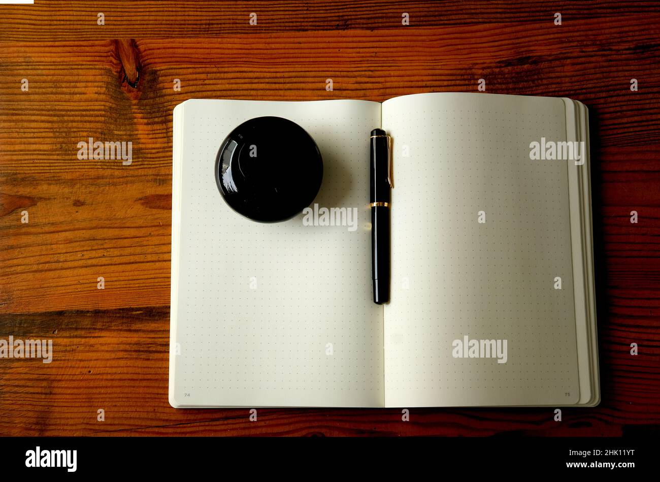 paper notebook, fountain pen and ink on wooden table flat lay Stock