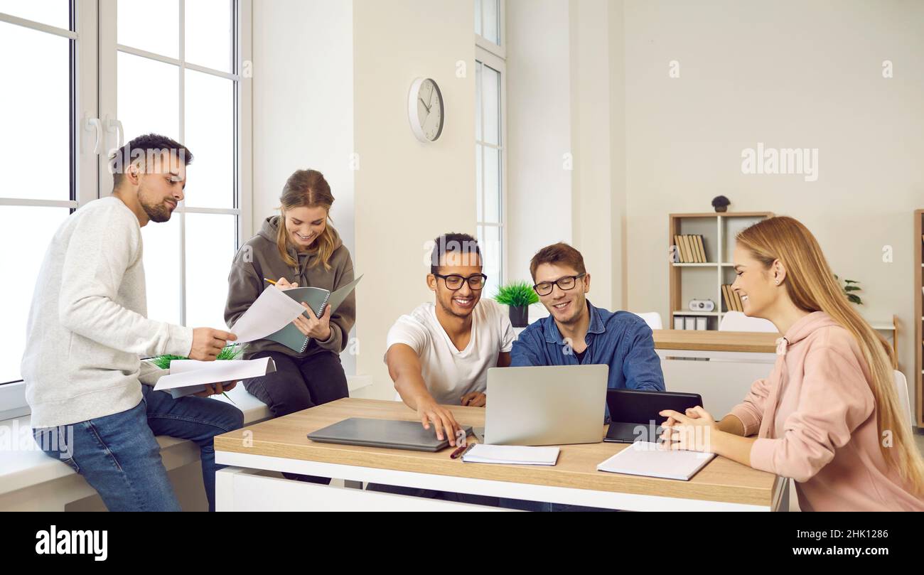 Group of happy university students using computers while studying together in the classroom Stock Photo