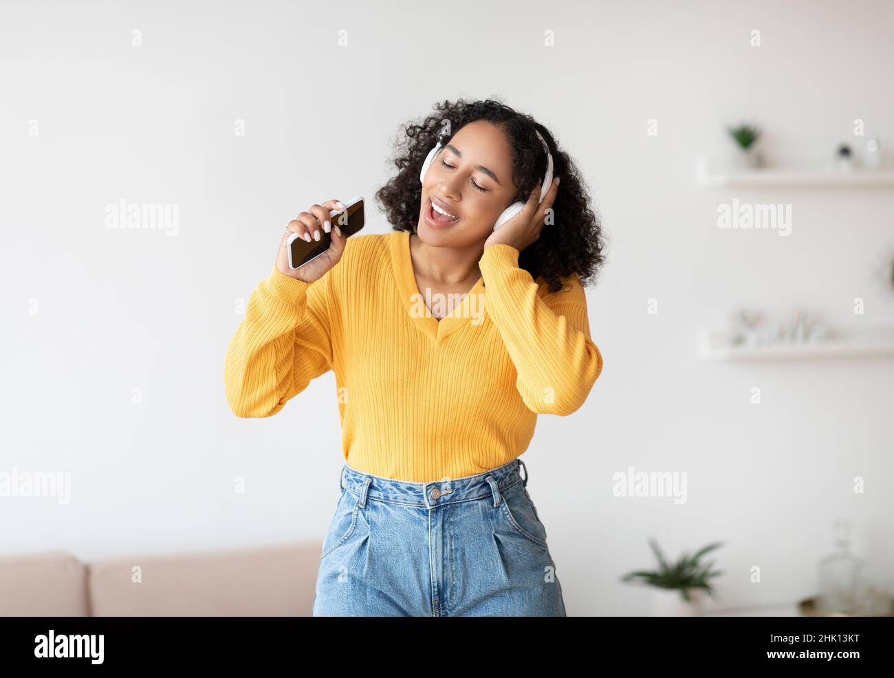 Cool karaoke or music app. Beautiful black woman in wireless headphones