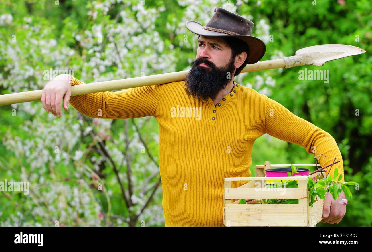 Professional gardener in garden with gardening tools. Bearded man in hat  with shovel. Spring work Stock Photo - Alamy
