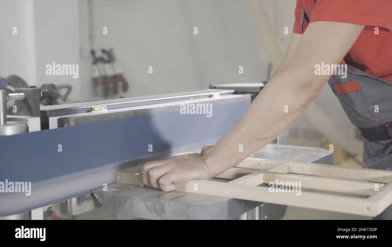 Wood surface grinding machine. Action. Professional carpenter grinds ...