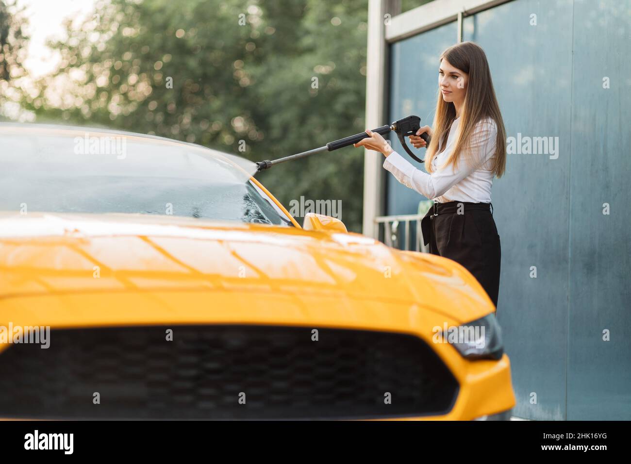 Female person hand with sponge scrubbing vehicle with foam, car wash. Young  woman on self-service automobile washing. Outdoor carwash Stock Photo -  Alamy