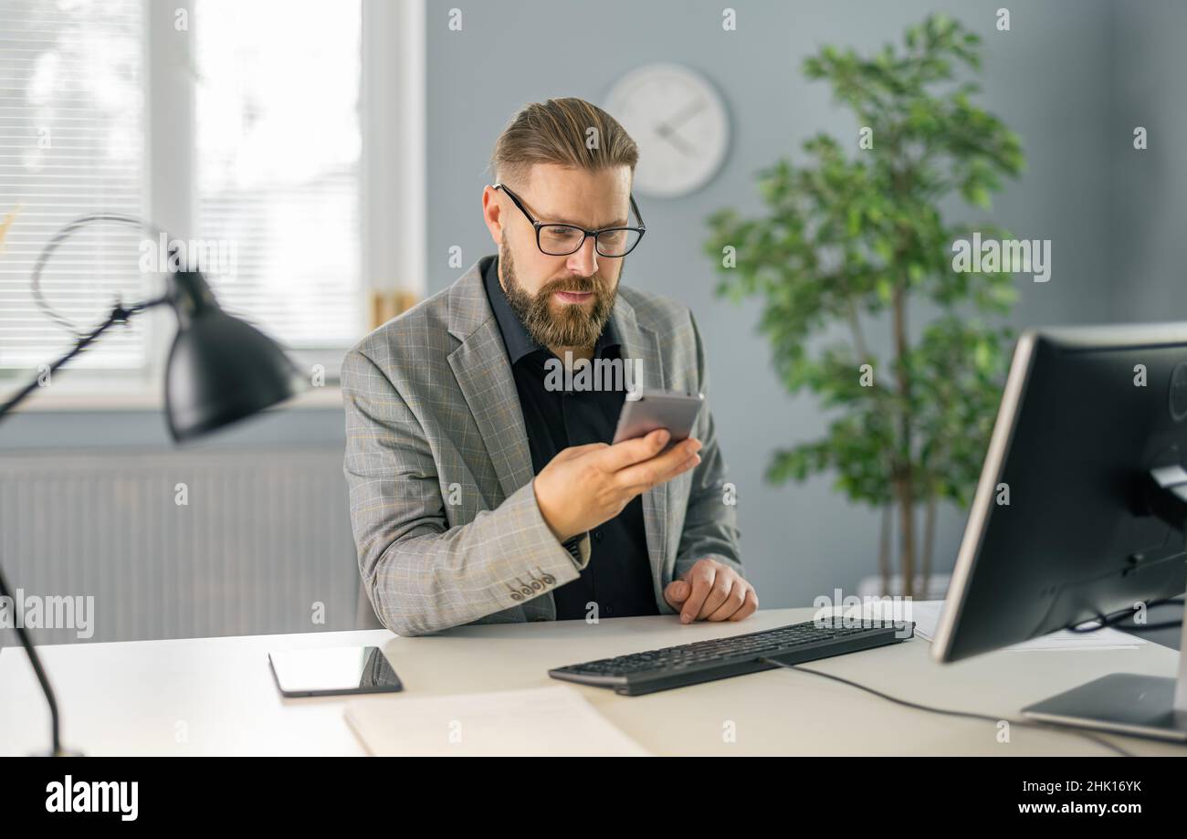 Man using smartphone at office Stock Photo