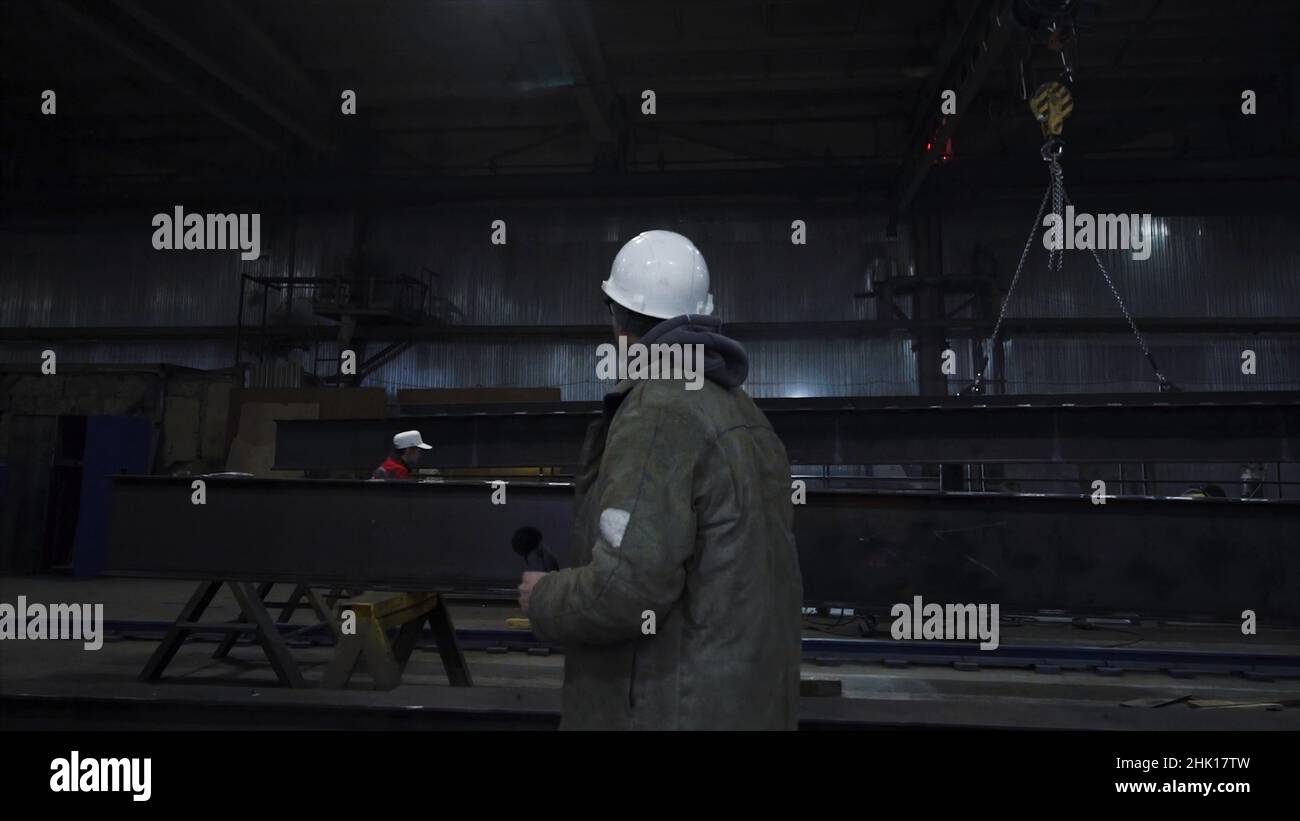 Man walks around factory and looks around. Clip. Foreman oversees work