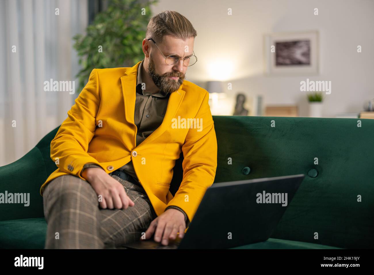 Man using laptop on sofa Stock Photo
