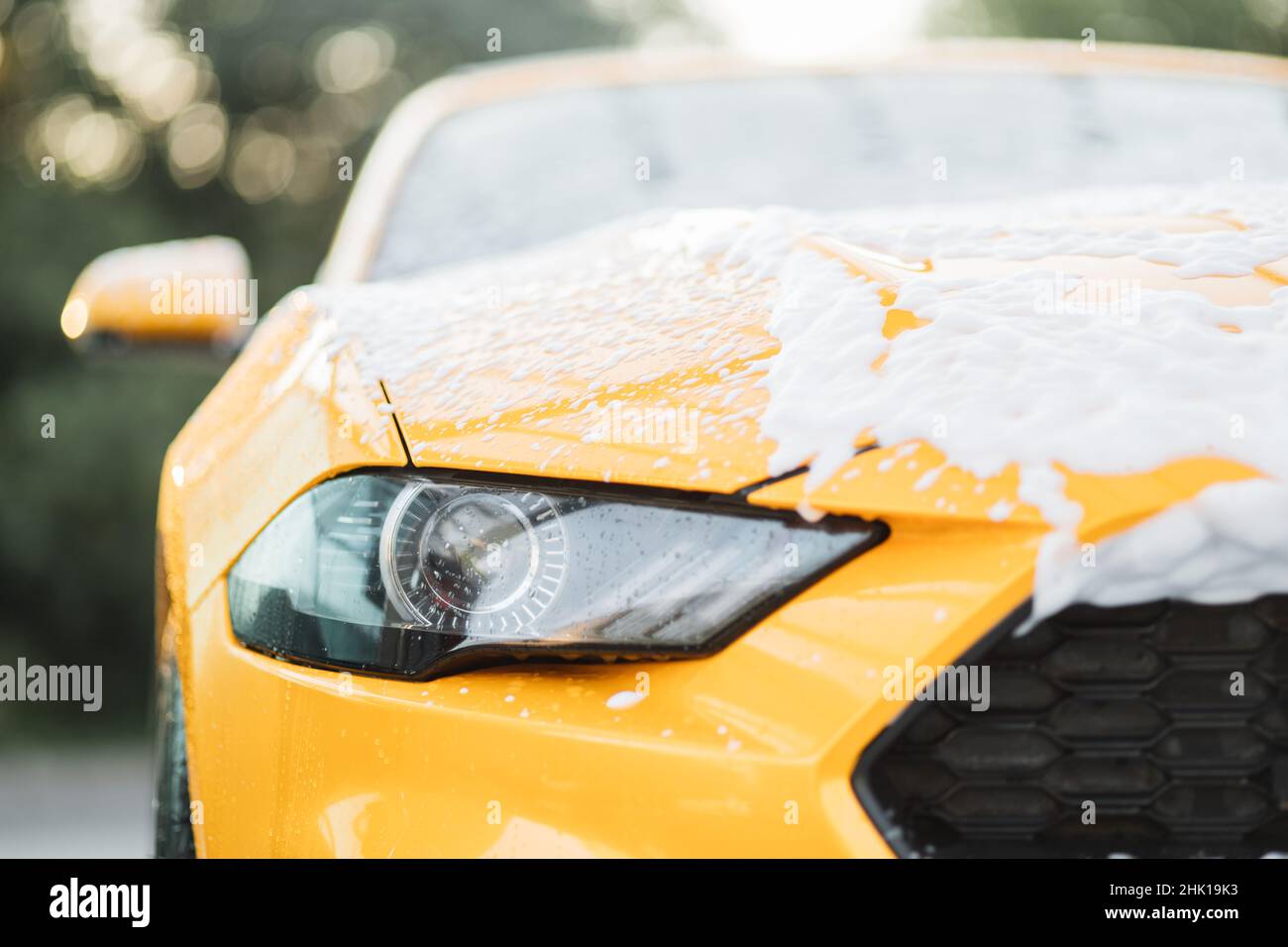 Close up horizontal shot of yellow car headlight with cleaning