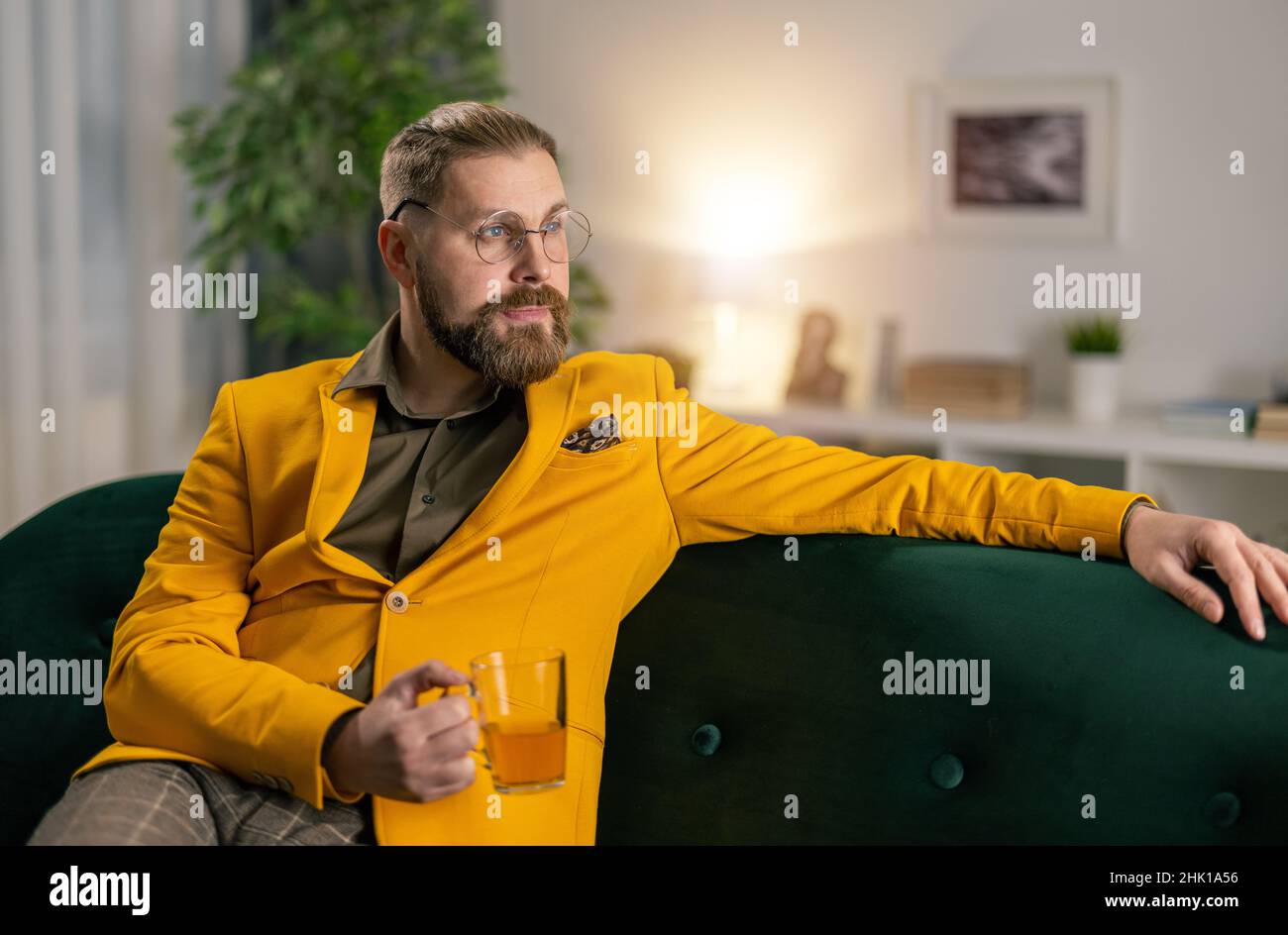 Man with tea on couch Stock Photo