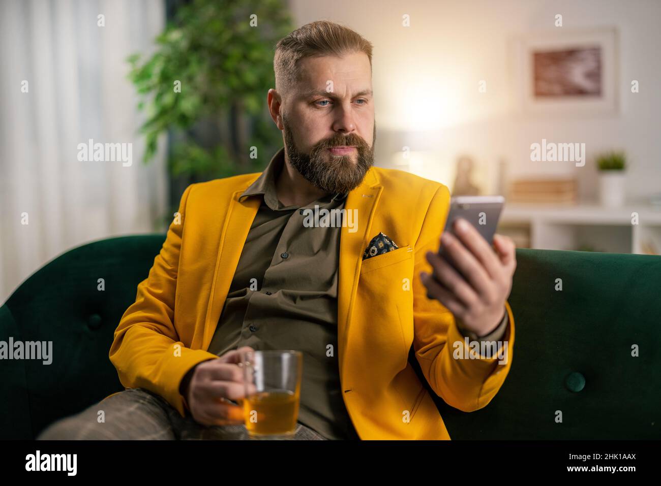 Man on couch with smartphone Stock Photo