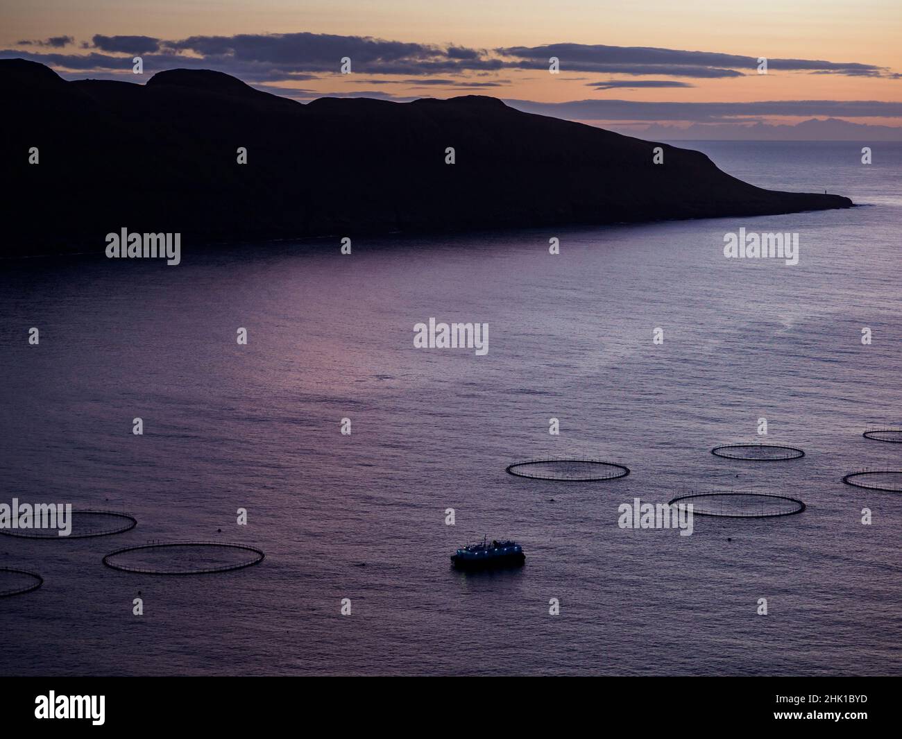 Magic sunrise with beautiful clouds over ocean and salmon farm, on Faroe Island. Denmark. Northern Europe Stock Photo