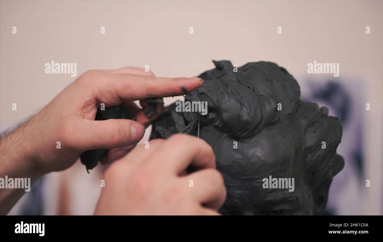 A sculptor who works on his clay sculpture in his Clip. Man