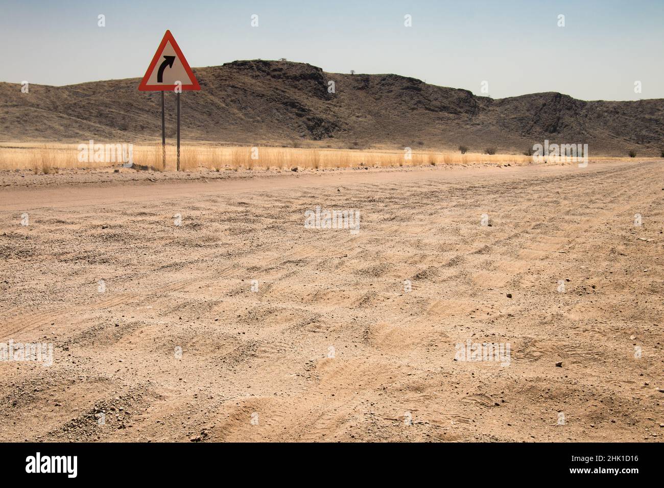 close up of a washboard gravel road and warning road sign in Namibia