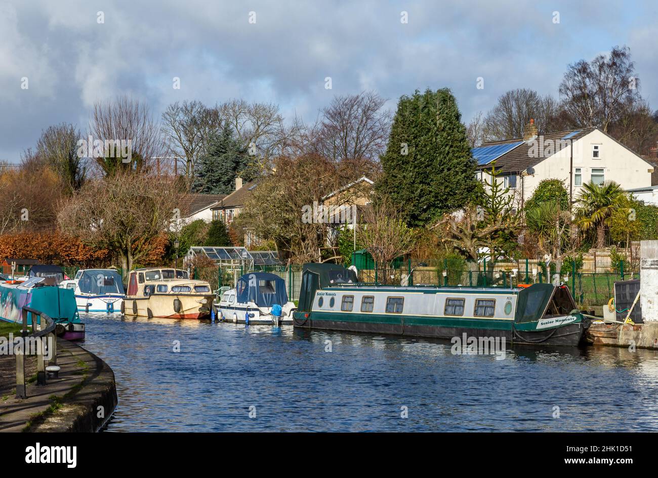 Cabin Cruisers and Narrowboats moored up on the Leeds Liverpool Canal in Bingley, West Yorkshire. Stock Photo