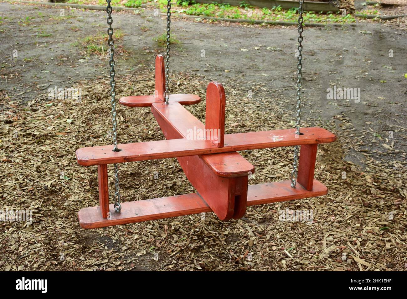 Decorative children's swing of skillful work is installed in the city park for riding Stock Photo