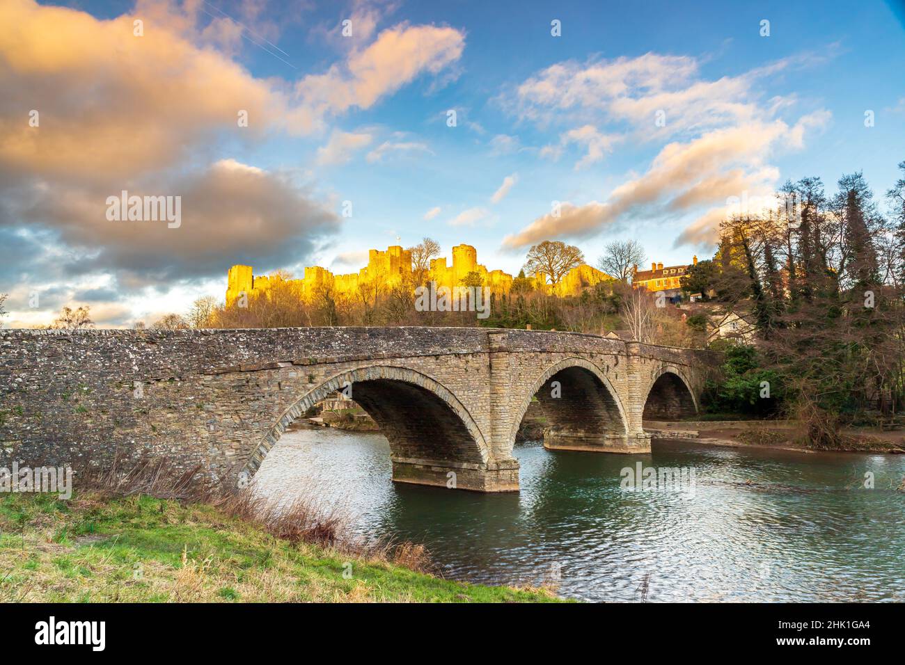 Dinham Bridge in Ludlow, Shropshire UK with the last sunlight of the day shining on the castle behind Stock Photo