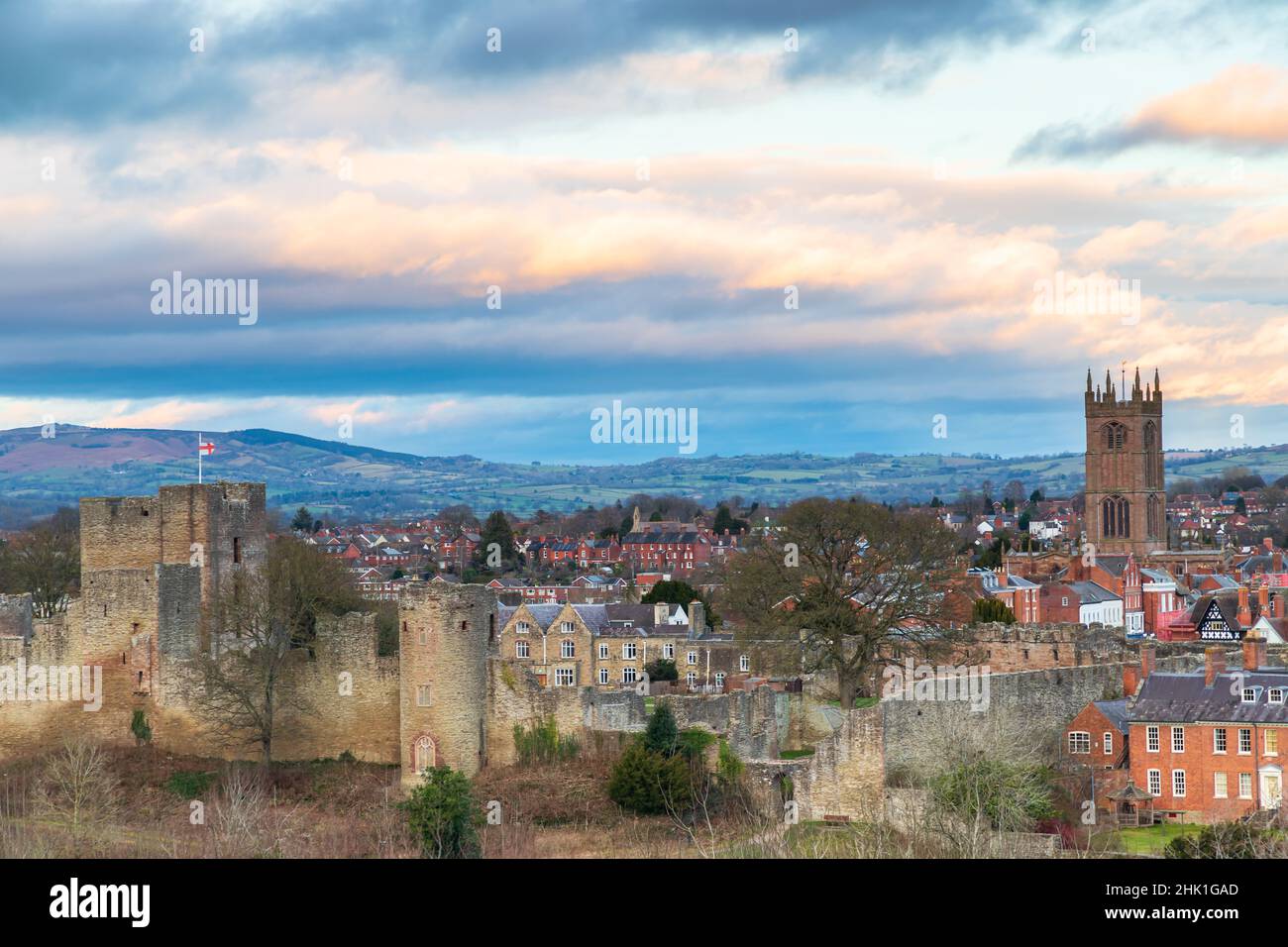 A view of the marrket town of Ludlow in Shropshire UK, showing the castle and St Lawrence's Church as the sun sets Stock Photo