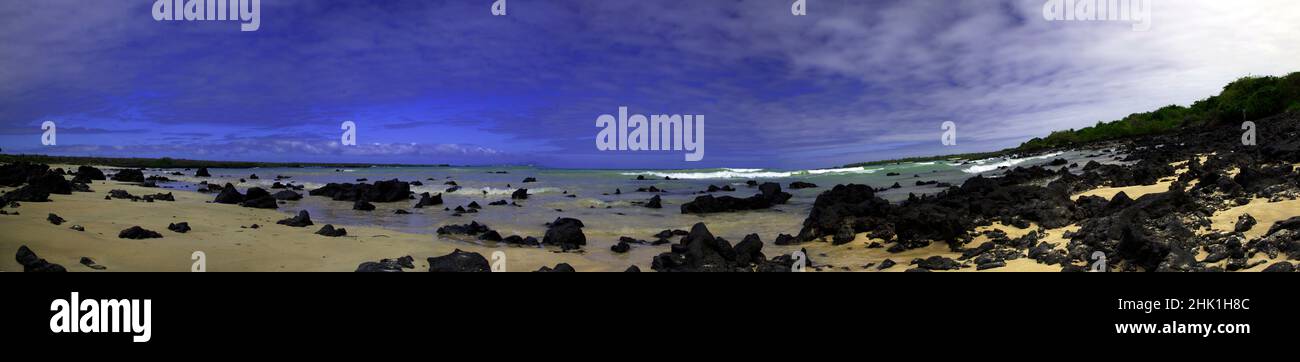 Panorama of black volcanic rocks laying on beach in the Galapagos Islands of Ecuador in South America. Stock Photo