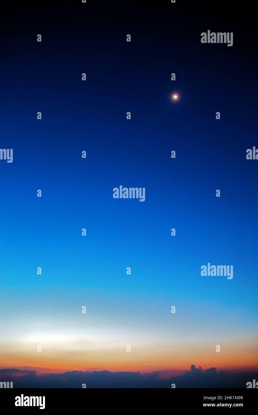 Crescent Moon in conjunction with Venus and Mars at dusk Stock Photo