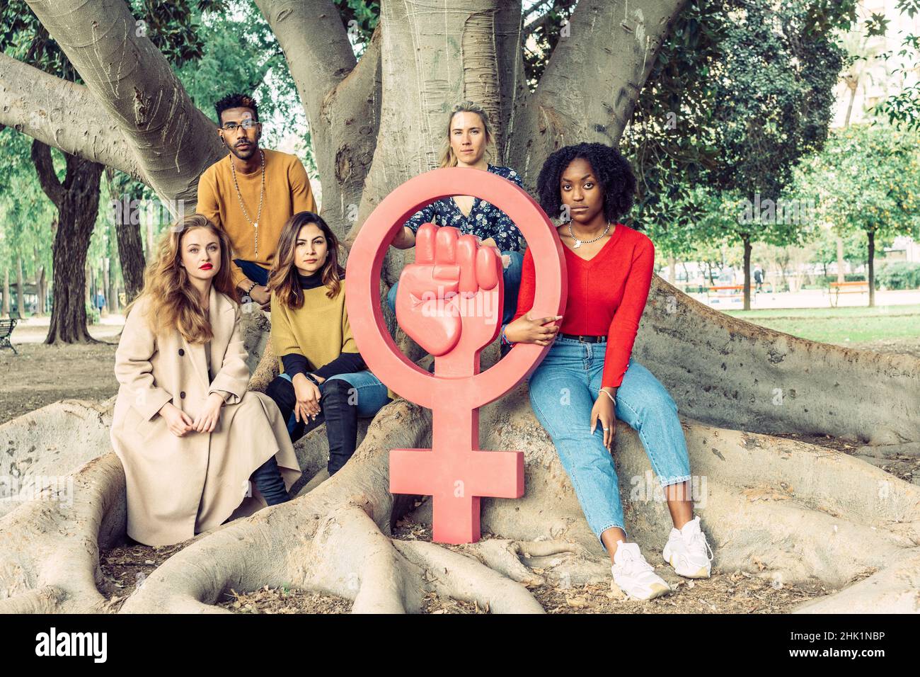 Group of people look defiantly at camera around large icon symbol of ...
