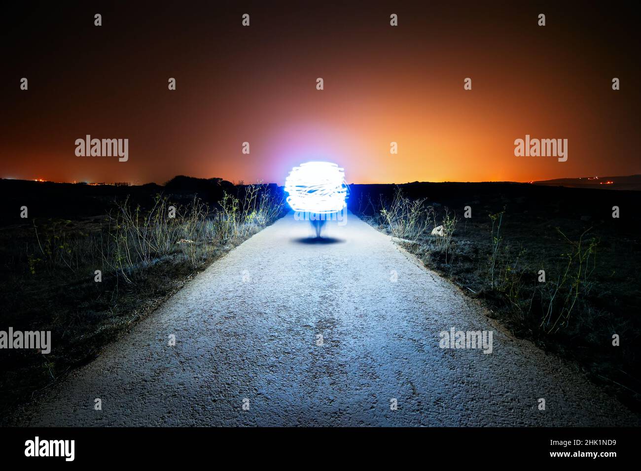 Orb like spaceship lands on a lone country road Stock Photo