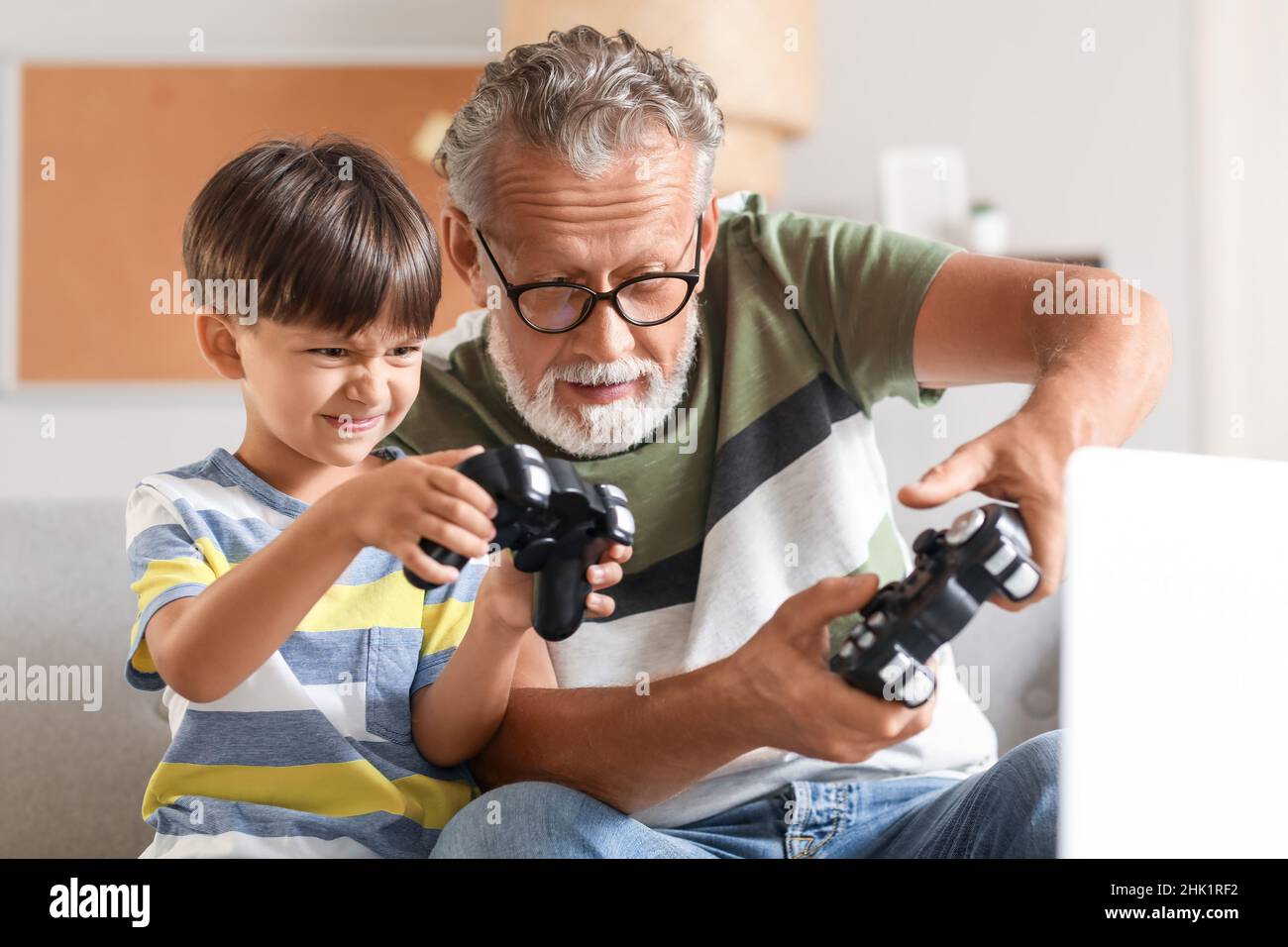 Little boy with his grandfather playing video game at home Stock Photo ...