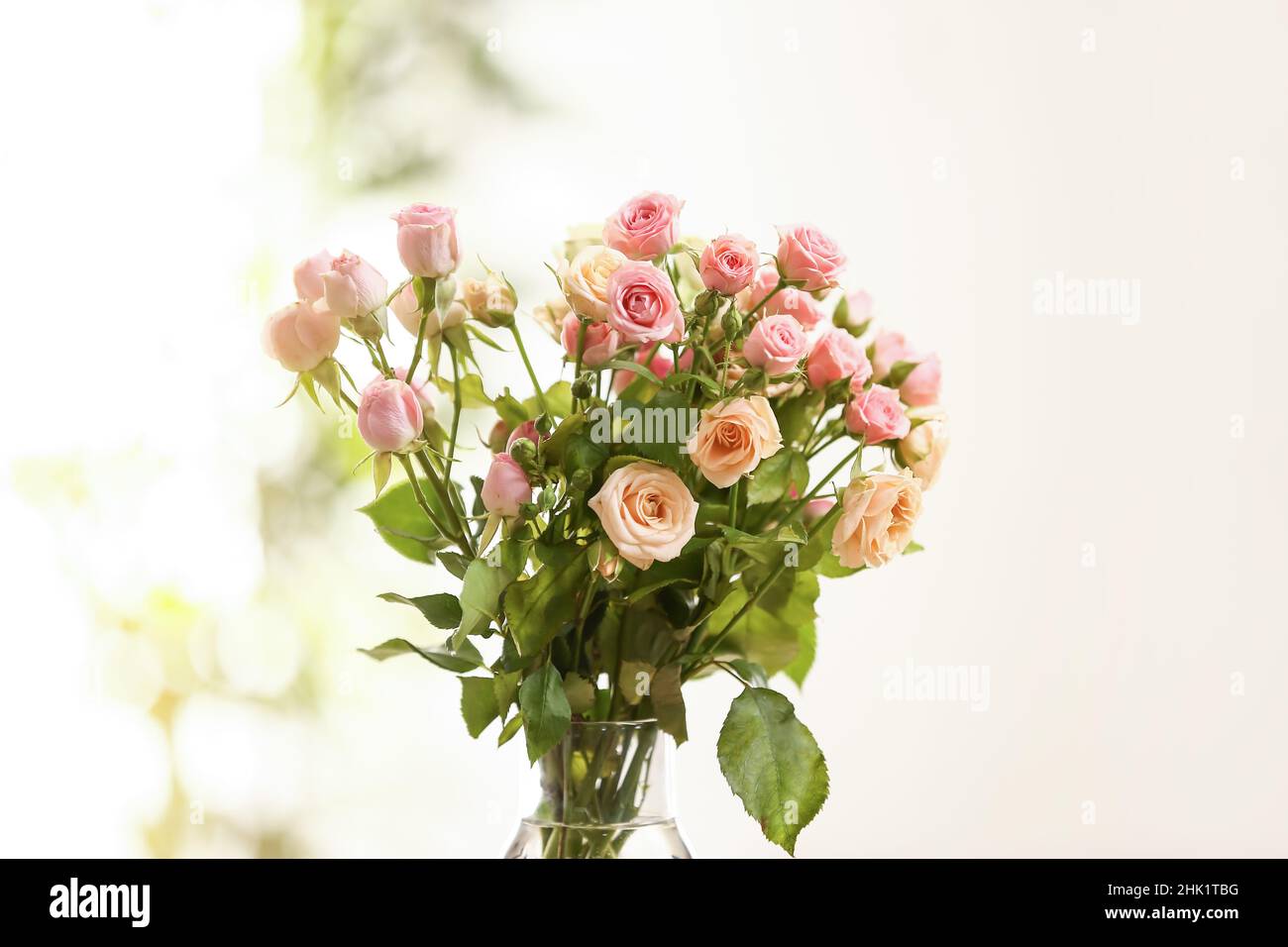 Bouquet of beautiful small roses on light background Stock Photo - Alamy