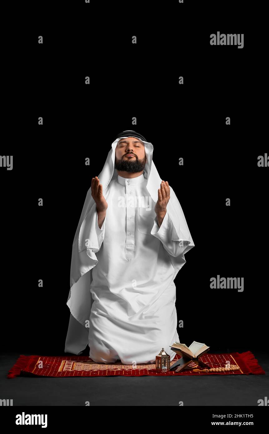 Muslim man praying on black background Stock Photo - Alamy