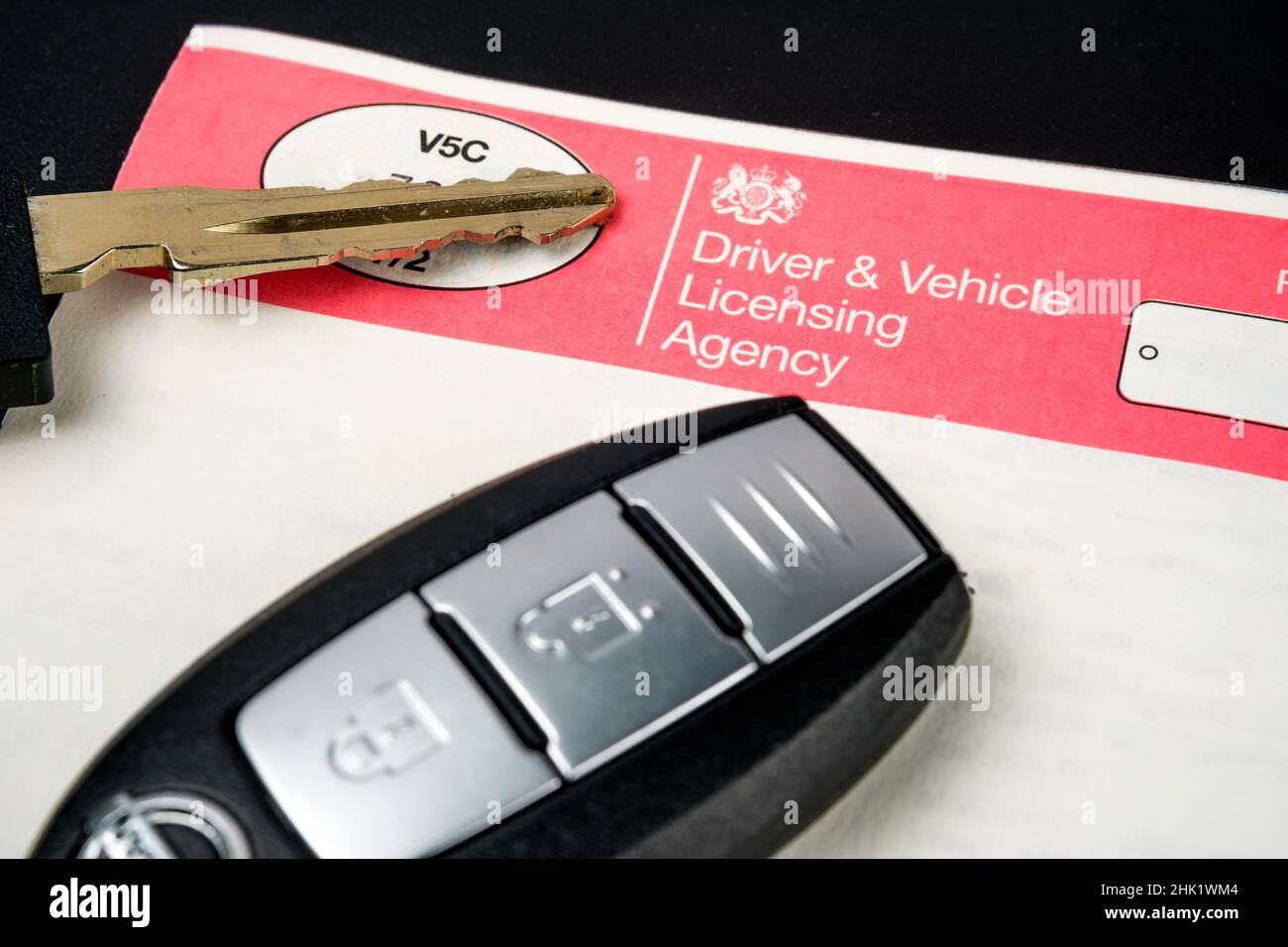 Genuine UK registration certificate for a purchased car and car key on top of it. Registration document also known as a vehicle log book V5C. Stafford Stock Photo