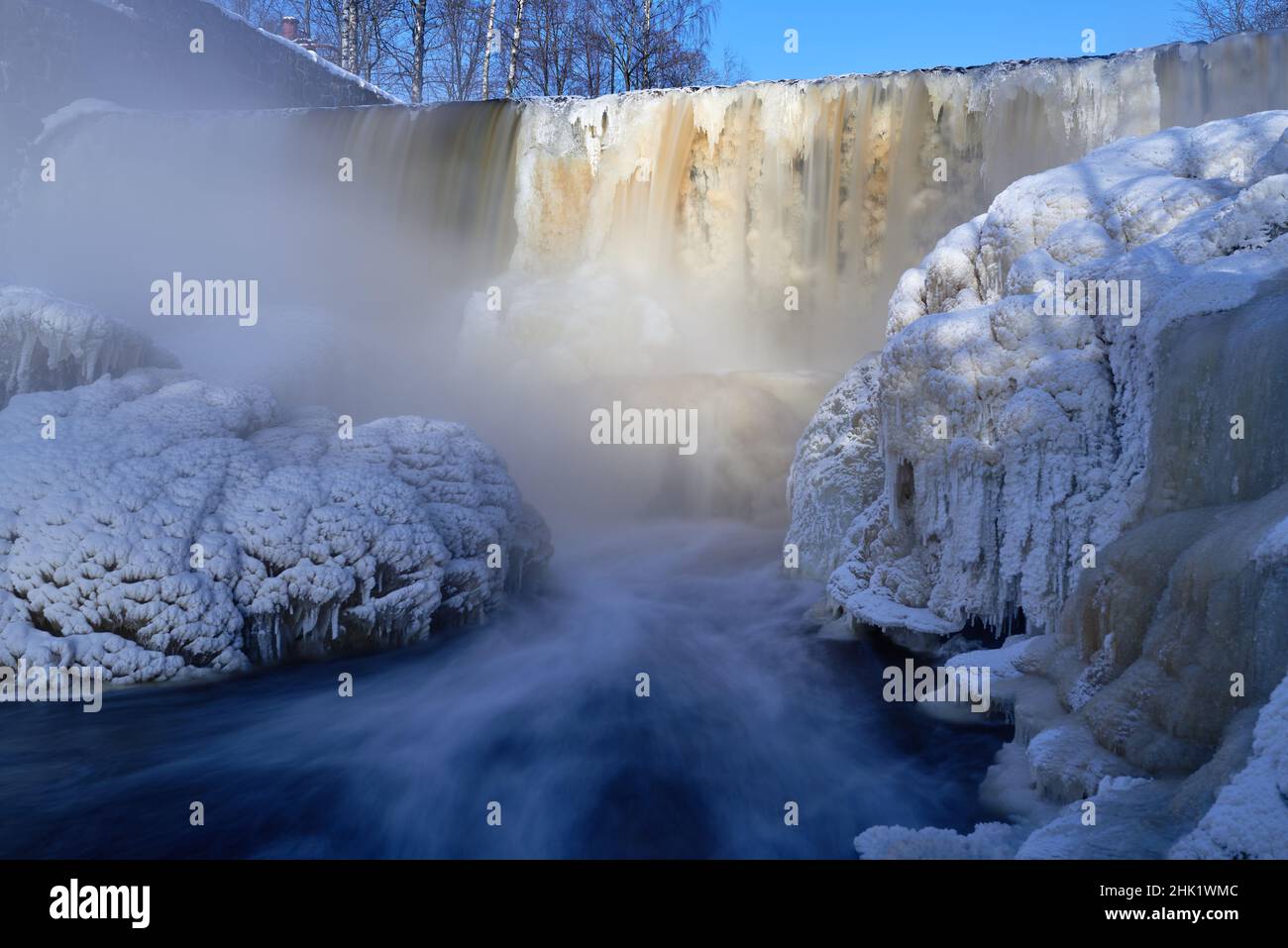 Water pours over frozen museum dam in the mouth of Vantaa River at the Vanhankaupunginkoski rapids (Vanhankaupunginkosken putous) on extremely cold wi Stock Photo