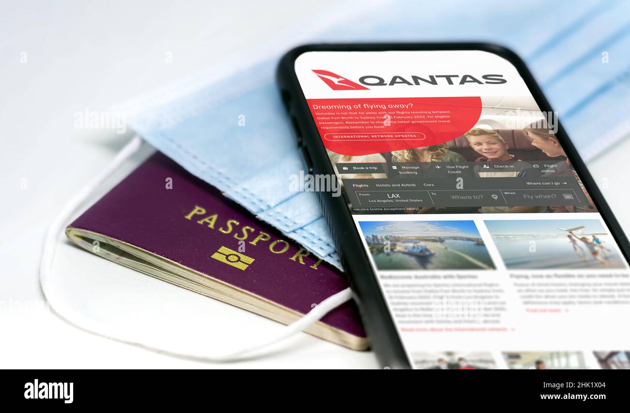 Sydney, Australia, July 2021: phone with the Qantas australian airlines app on the screen lying over a protective mask and a passport. Travel safety a Stock Photo