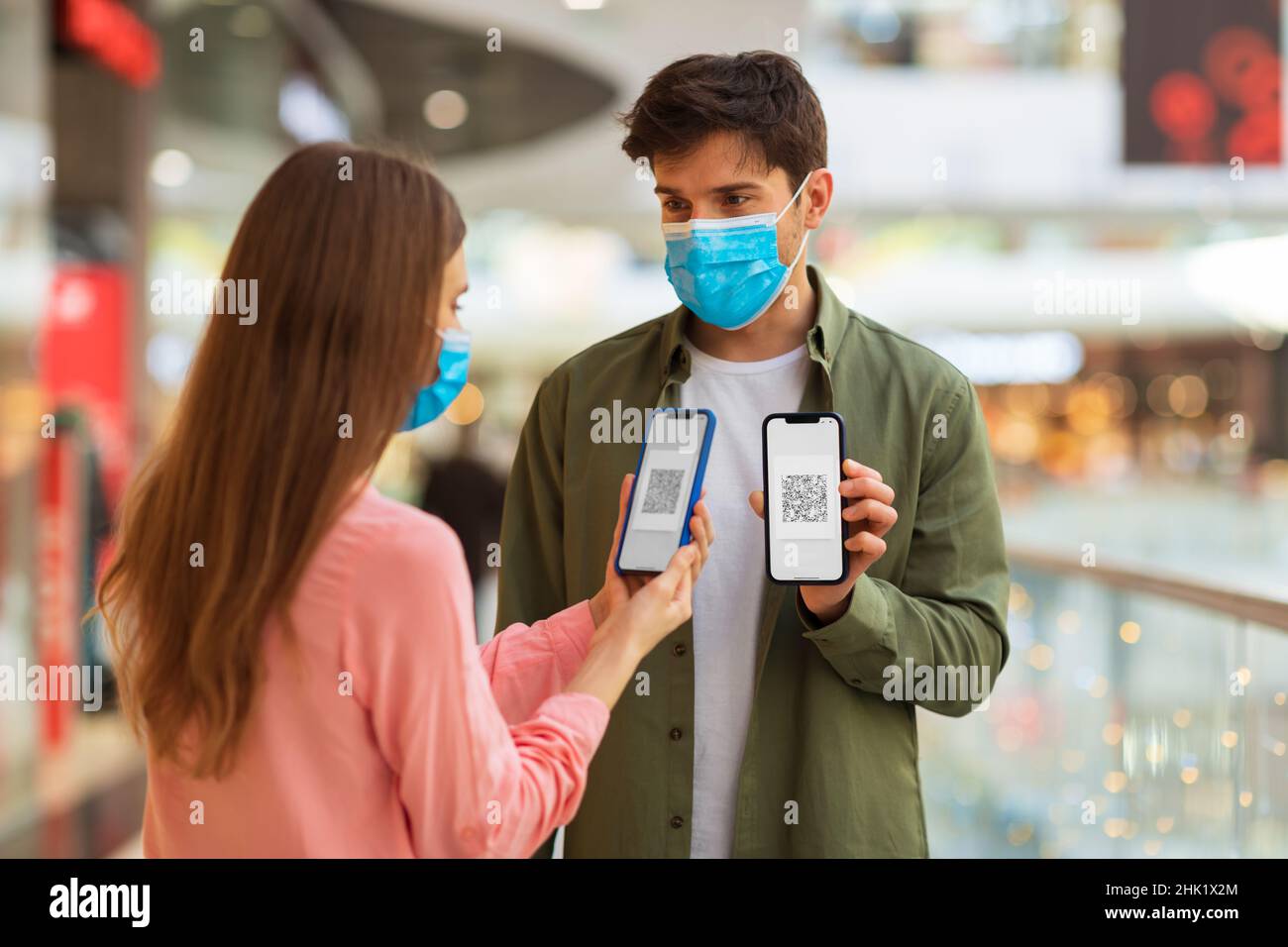 Couple Wearing Masks Showing Cellphones With QR Code In Mall Stock ...