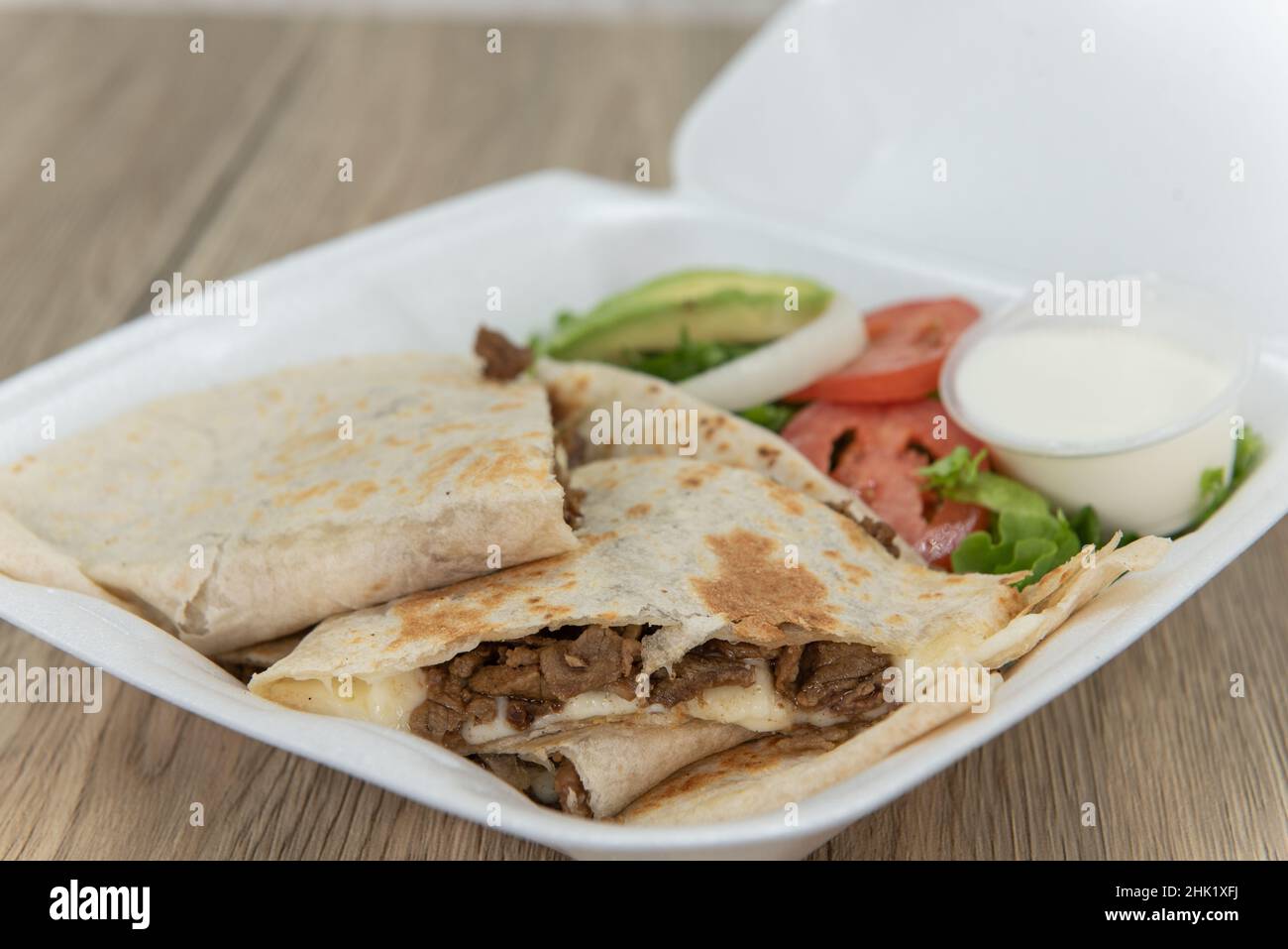 Take out order of carne asada tortilla quesadillas cut into triangle pieces and served in styrofoam box. Stock Photo