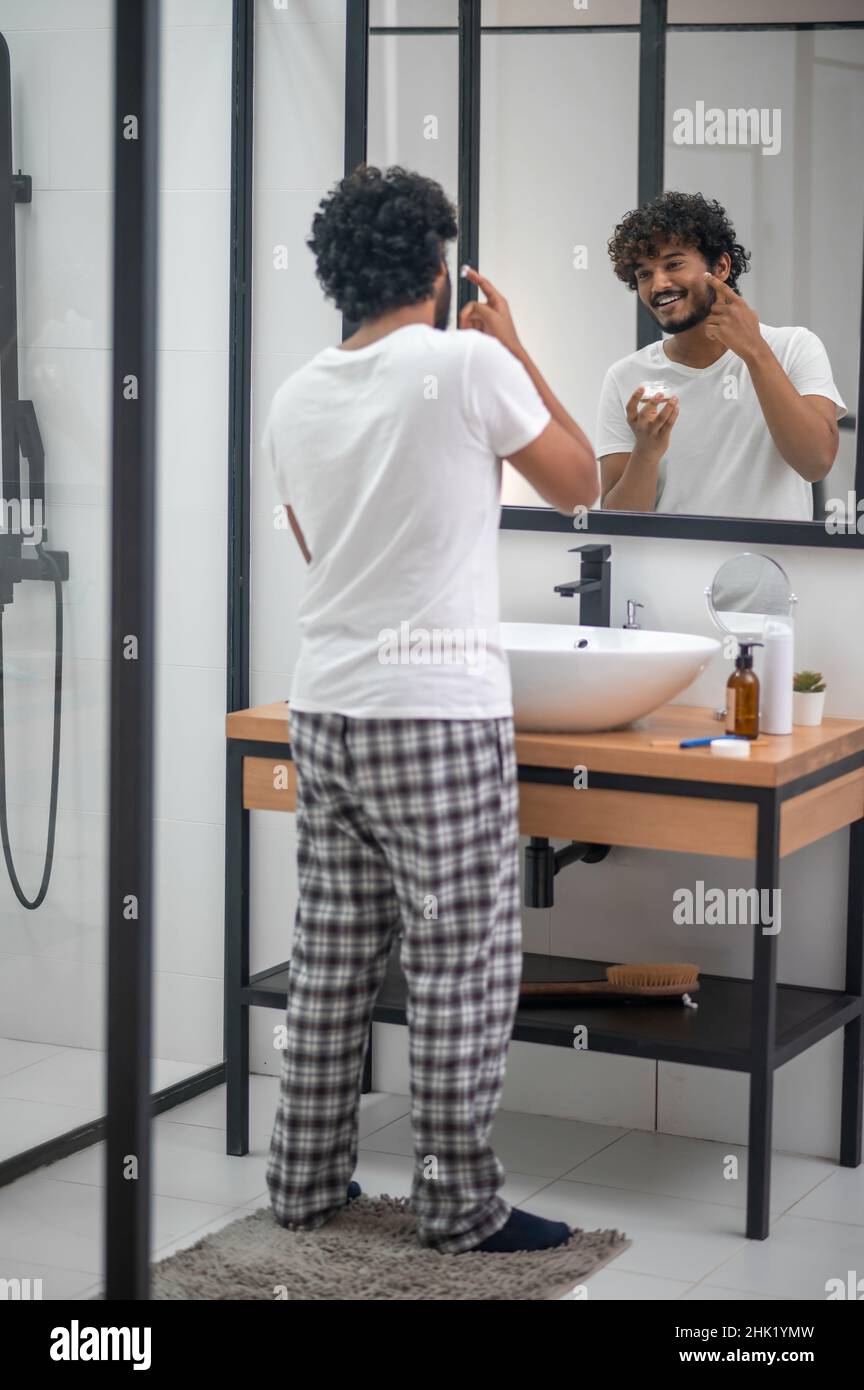 Pleased young man getting ready for shaving Stock Photo