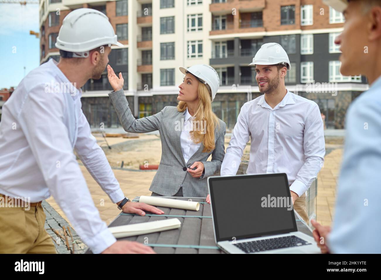 Concentrated building inspector communicating with builders outdoors ...