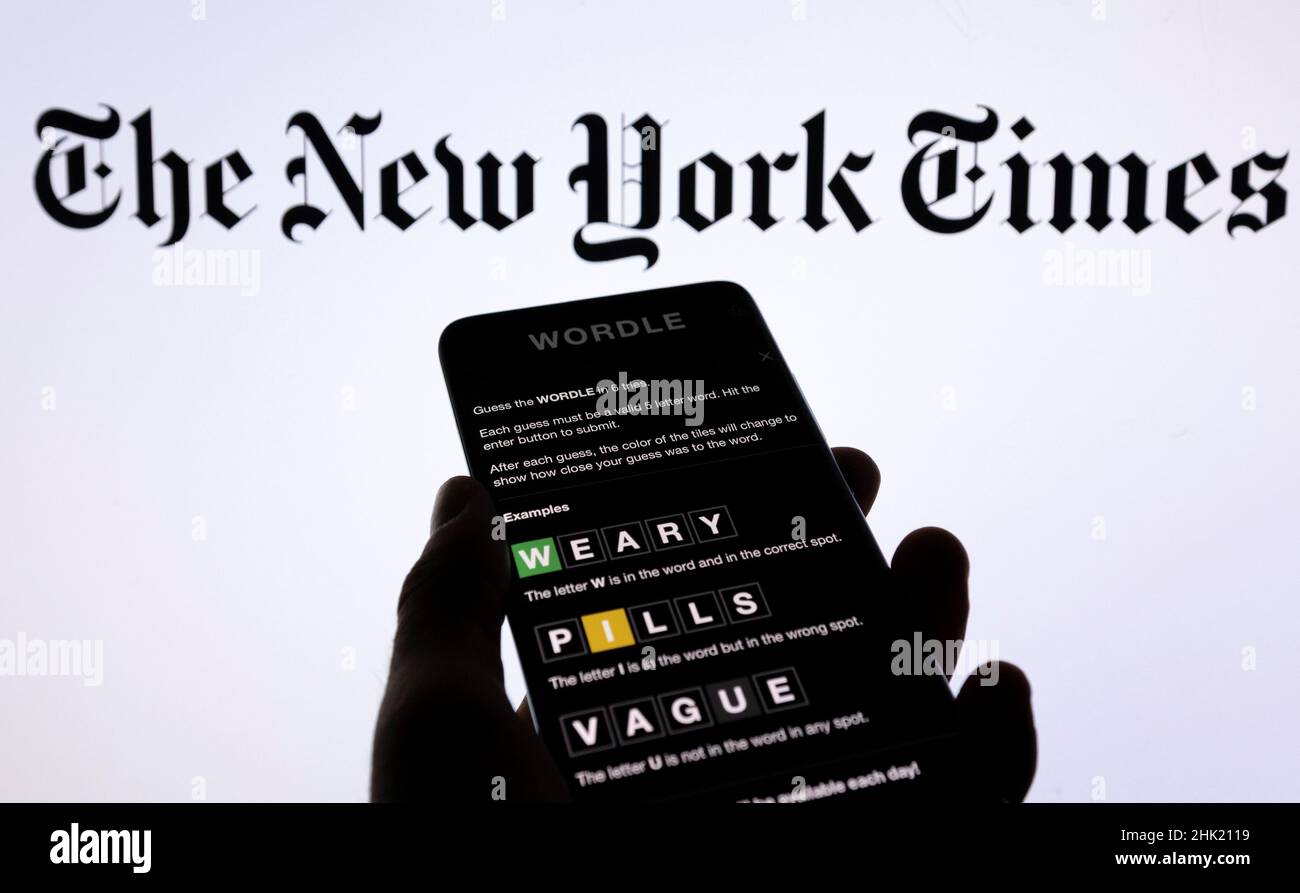 Wordle app game is seen on a smartphone in front of The New York Times