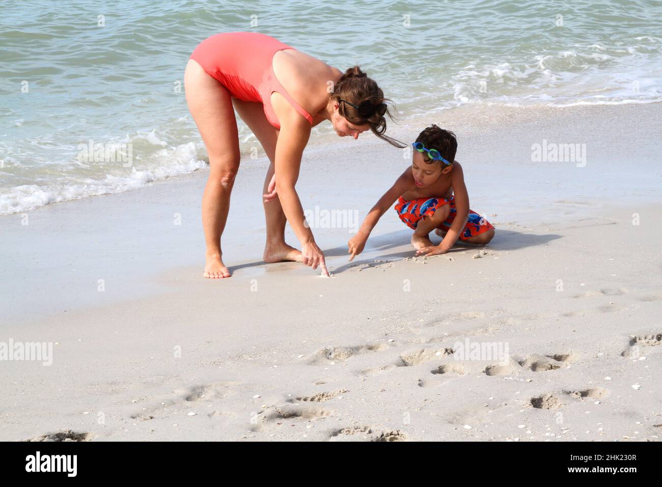 Mother and child playing in the sand Stock Photo