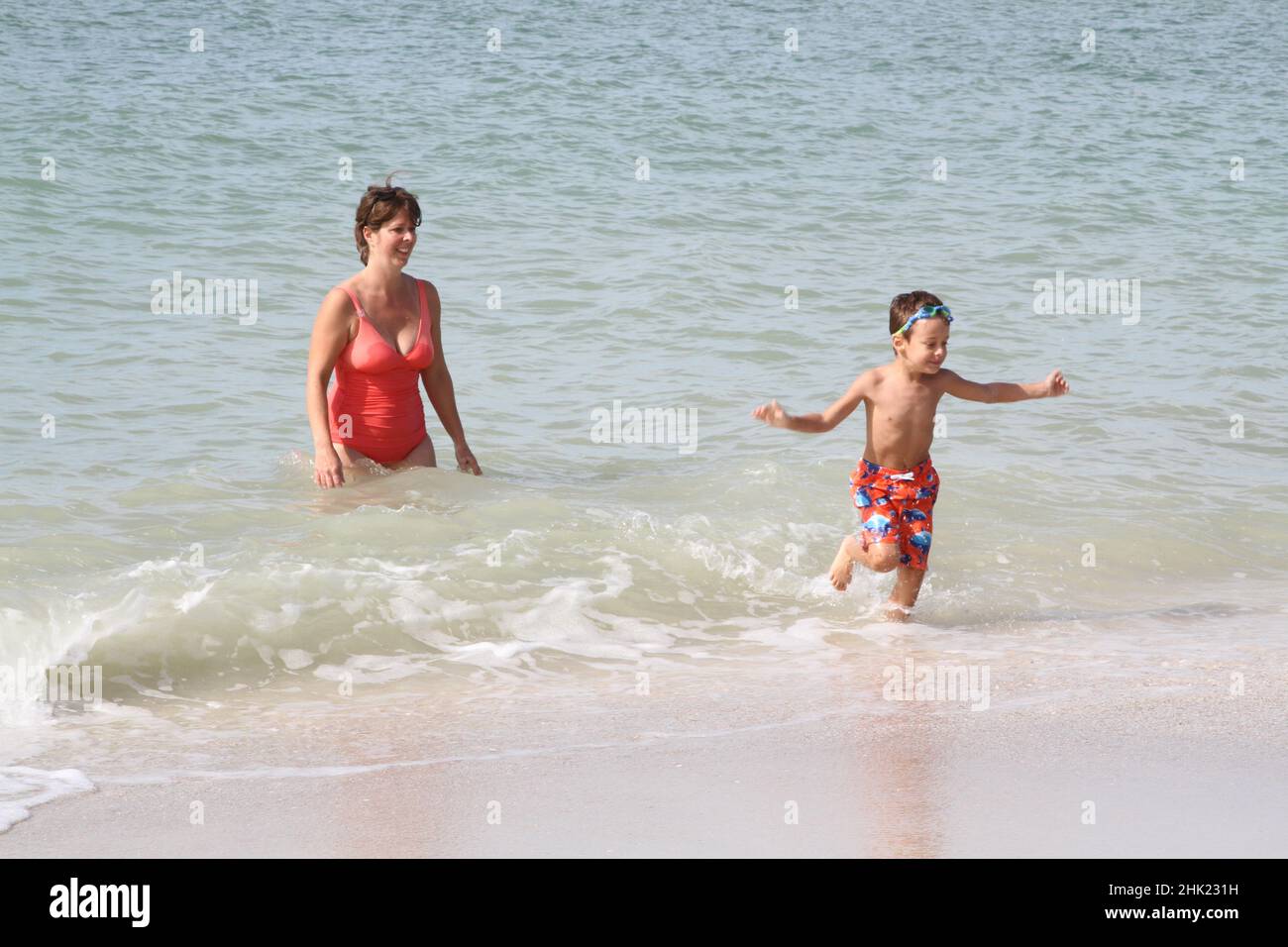 Woman and boy enjoying ocean waves in Florda Stock Photo