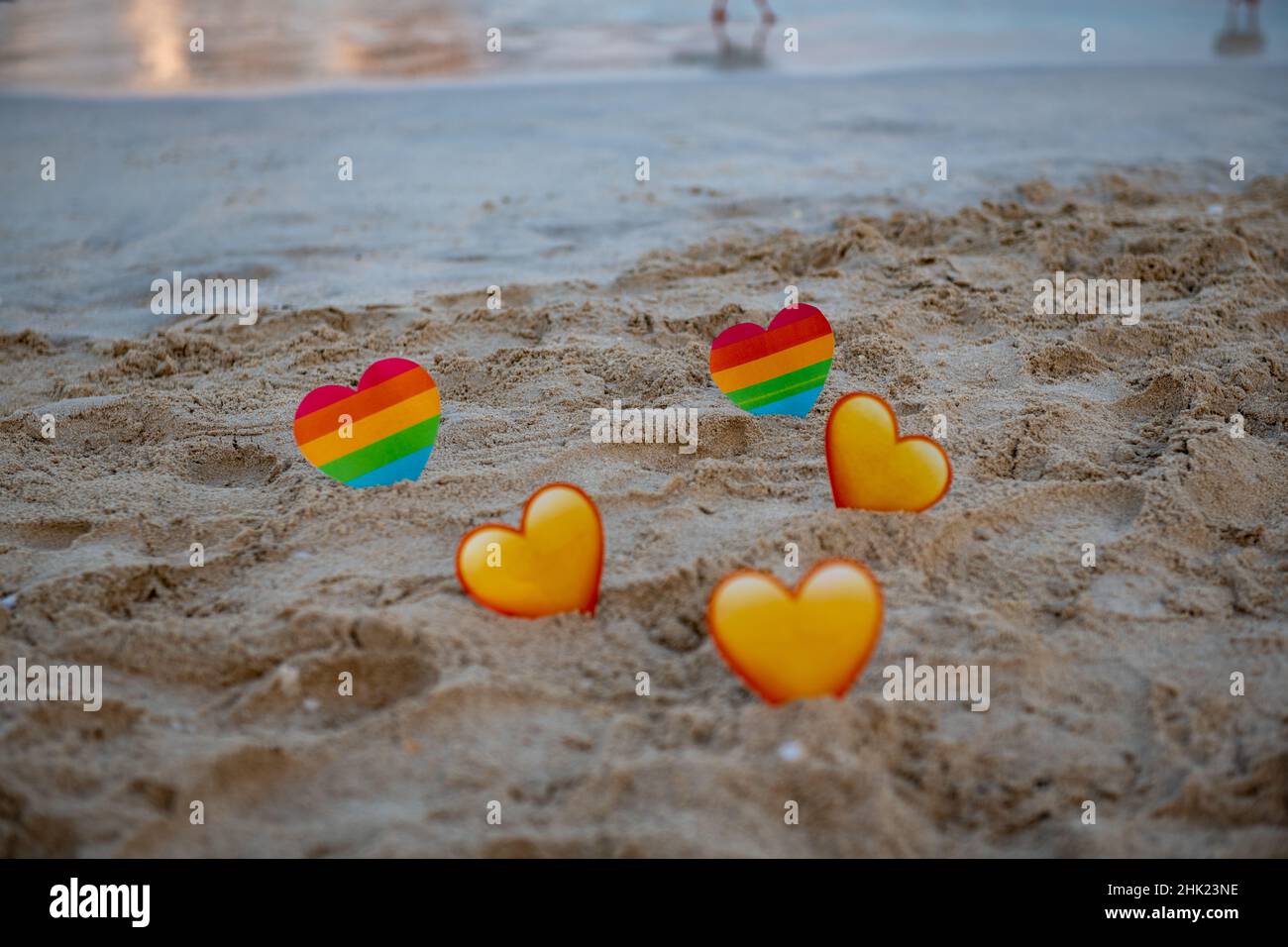 lgbt and yellow hearts in the sand stand on the sea Stock Photo