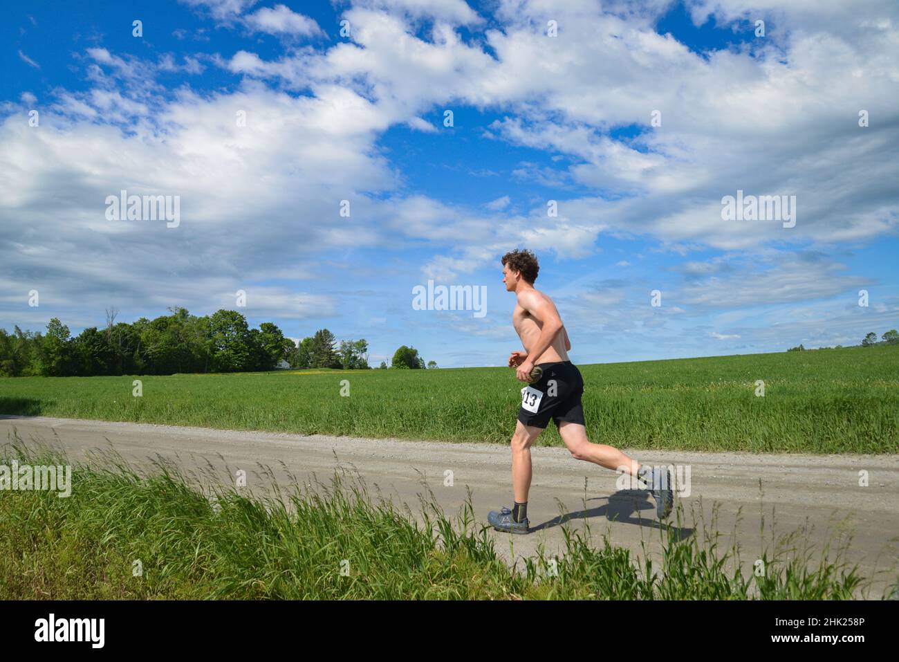 Runners compete in a road race on dirt roads in the area of Vermont's (USA) Northeast Kingdom near the Craftsbury Outdoor Center. Stock Photo