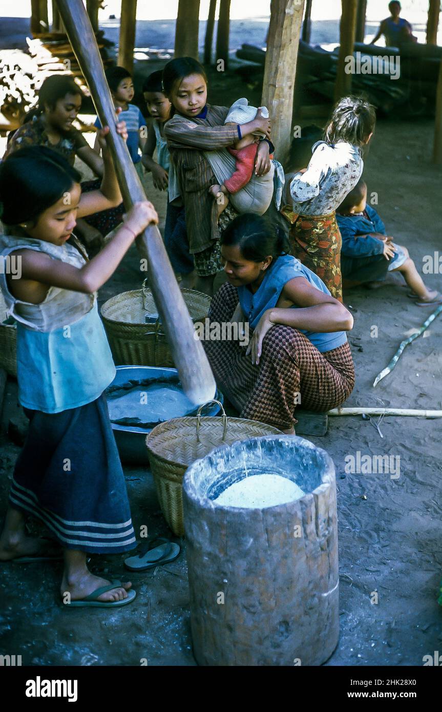 Villagers pounding rice, near Luang Prabang, Laos, 1974 Stock Photo