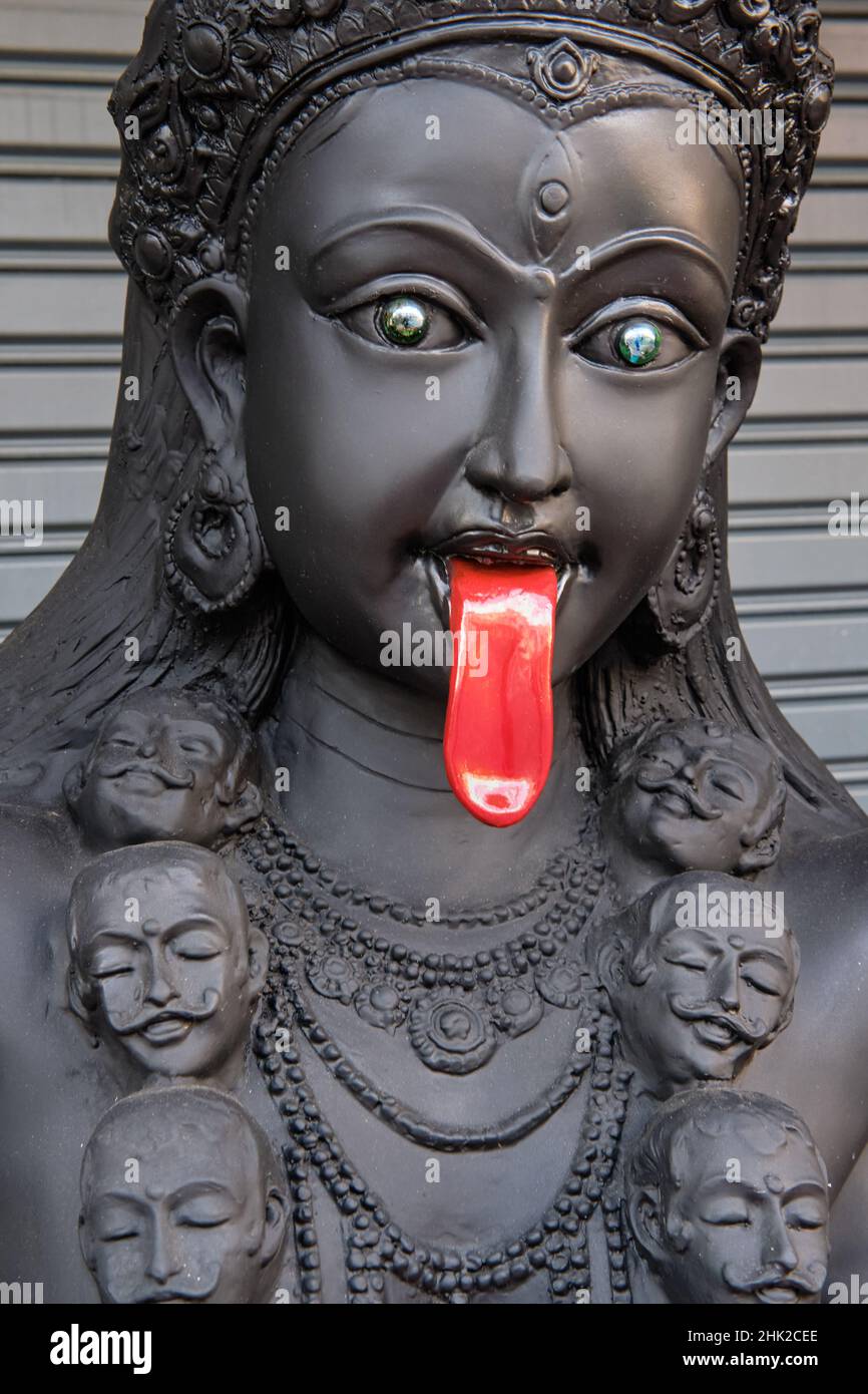 Black statue of Hindu goddess Kali with a blooddripping red tongue
