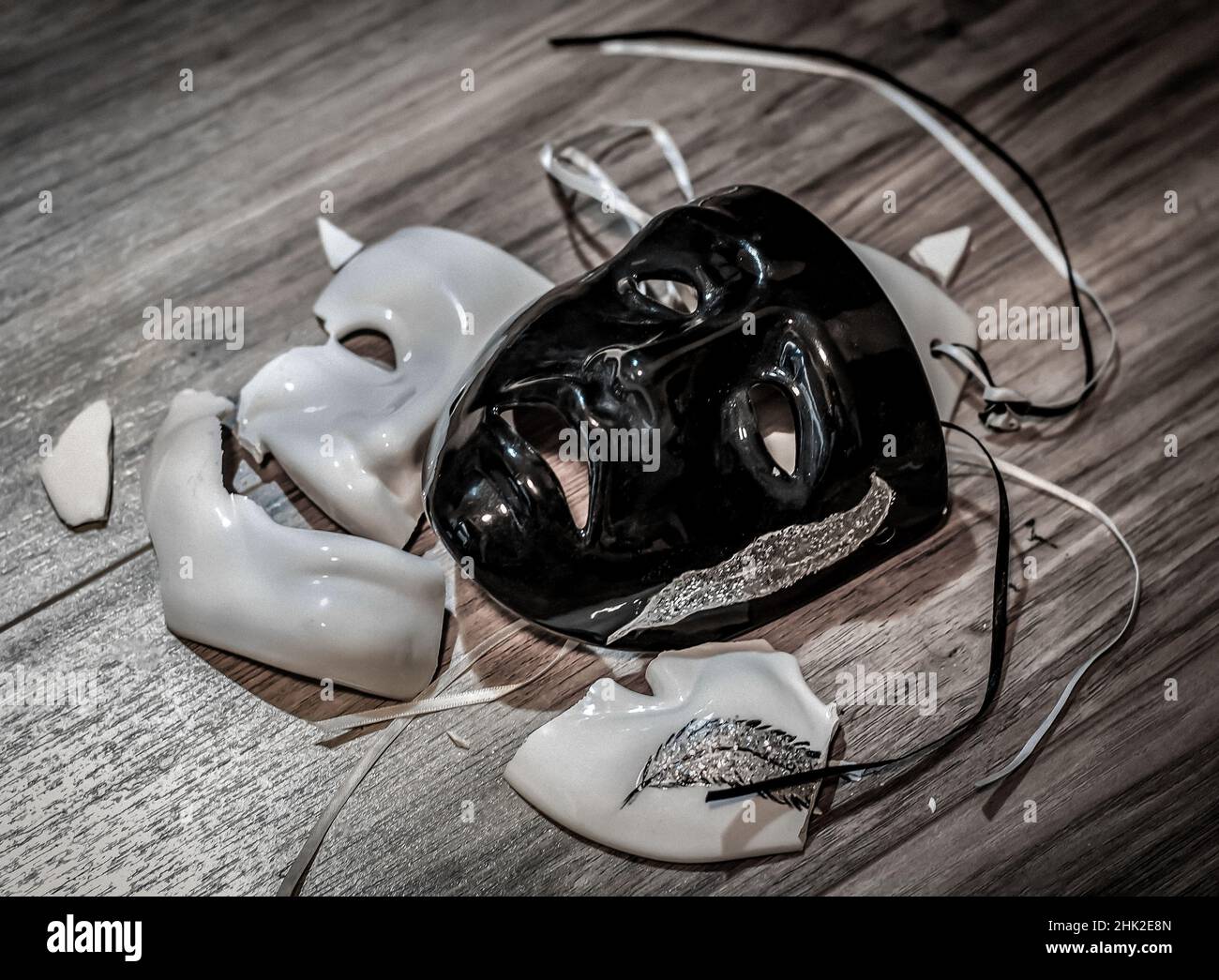 Two masks with happy and sad emotions lying on the ground Stock Photo