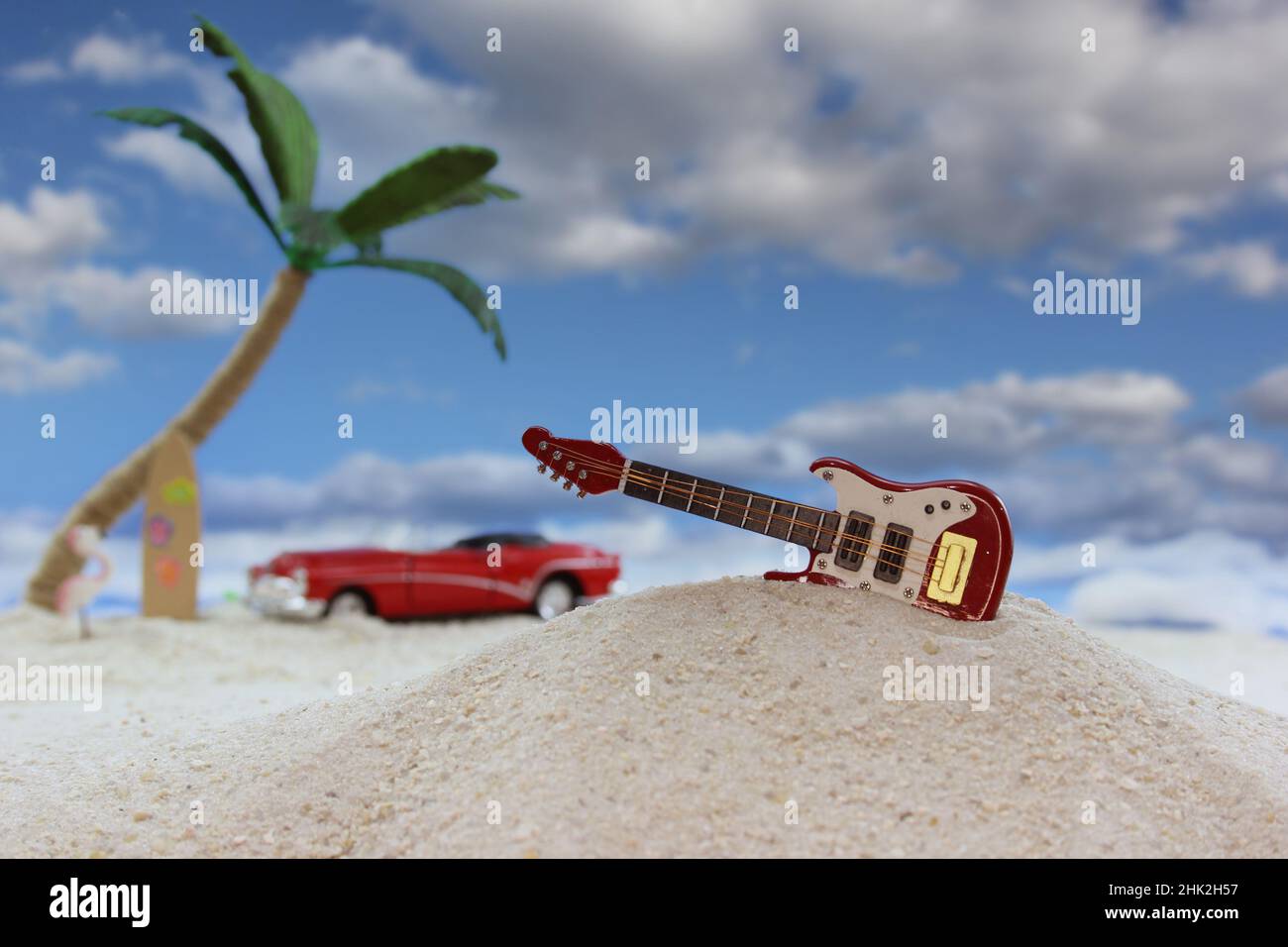 Red Guitar on Tropical Beach With Palm Trees in Background Stock Photo