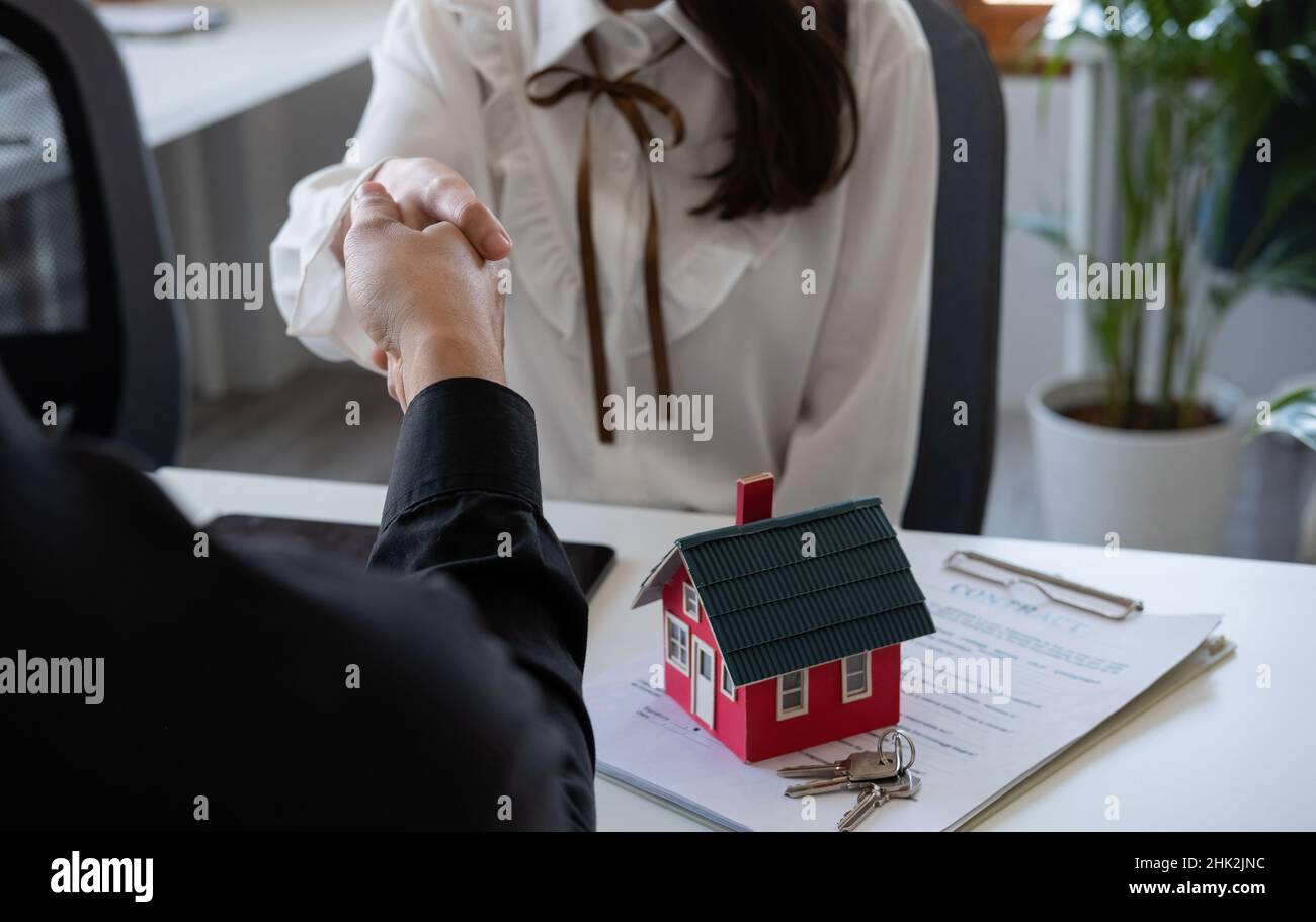 Estate agent and customer shaking hands after fafter signing contract about home insurance and investment loan. Stock Photo