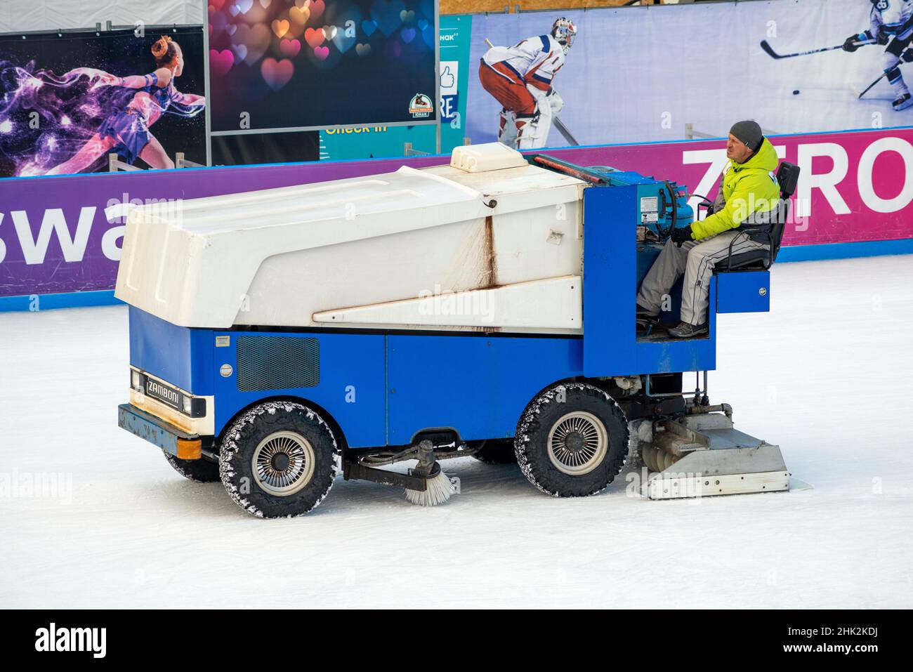 Worker using old rusty ice resurfacer Zamboni resurfacing machine for